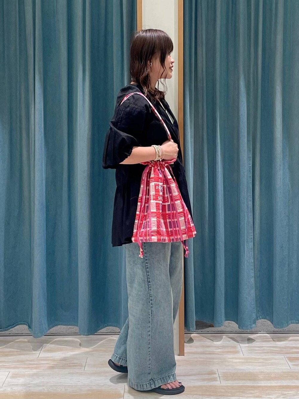 ホワイト系のキャミソール、ブルー系のデニムパンツ、ピンク系のトートバッグを着用したレディースの春コーディネートの2枚目の写真