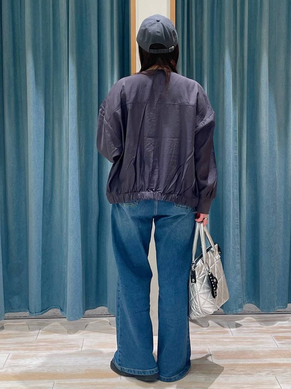 ブルー系のデニムパンツ、グレー系のブルゾン、シルバー系のトートバッグを着用したレディースの春コーディネートの3枚目の写真