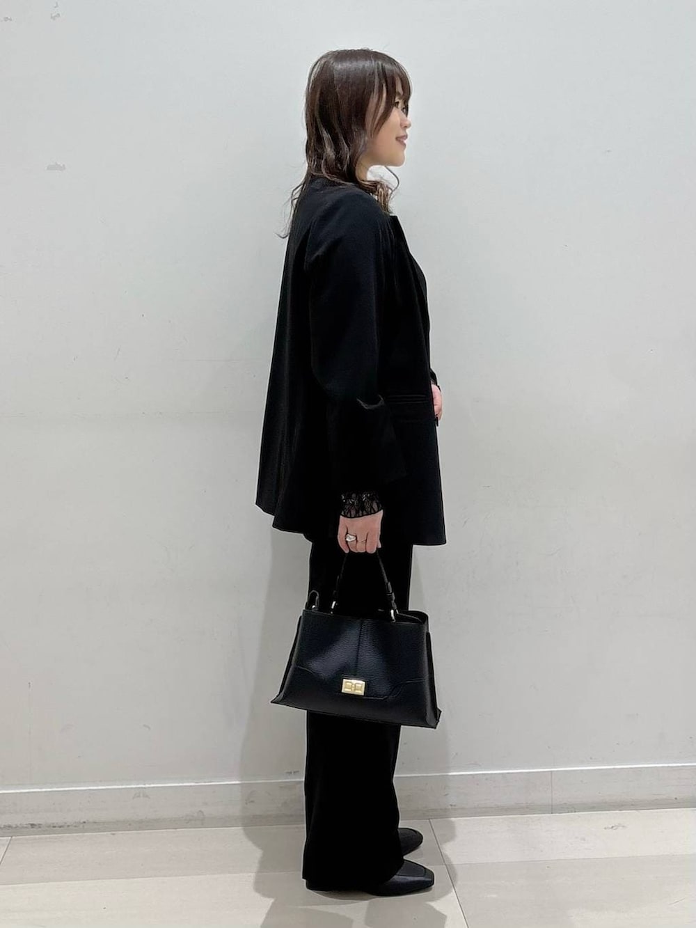 ブラック系のローファー、ブラック系のTシャツ/カットソー、ブラック系のスラックスを着用したレディースの冬コーディネートの2枚目の写真