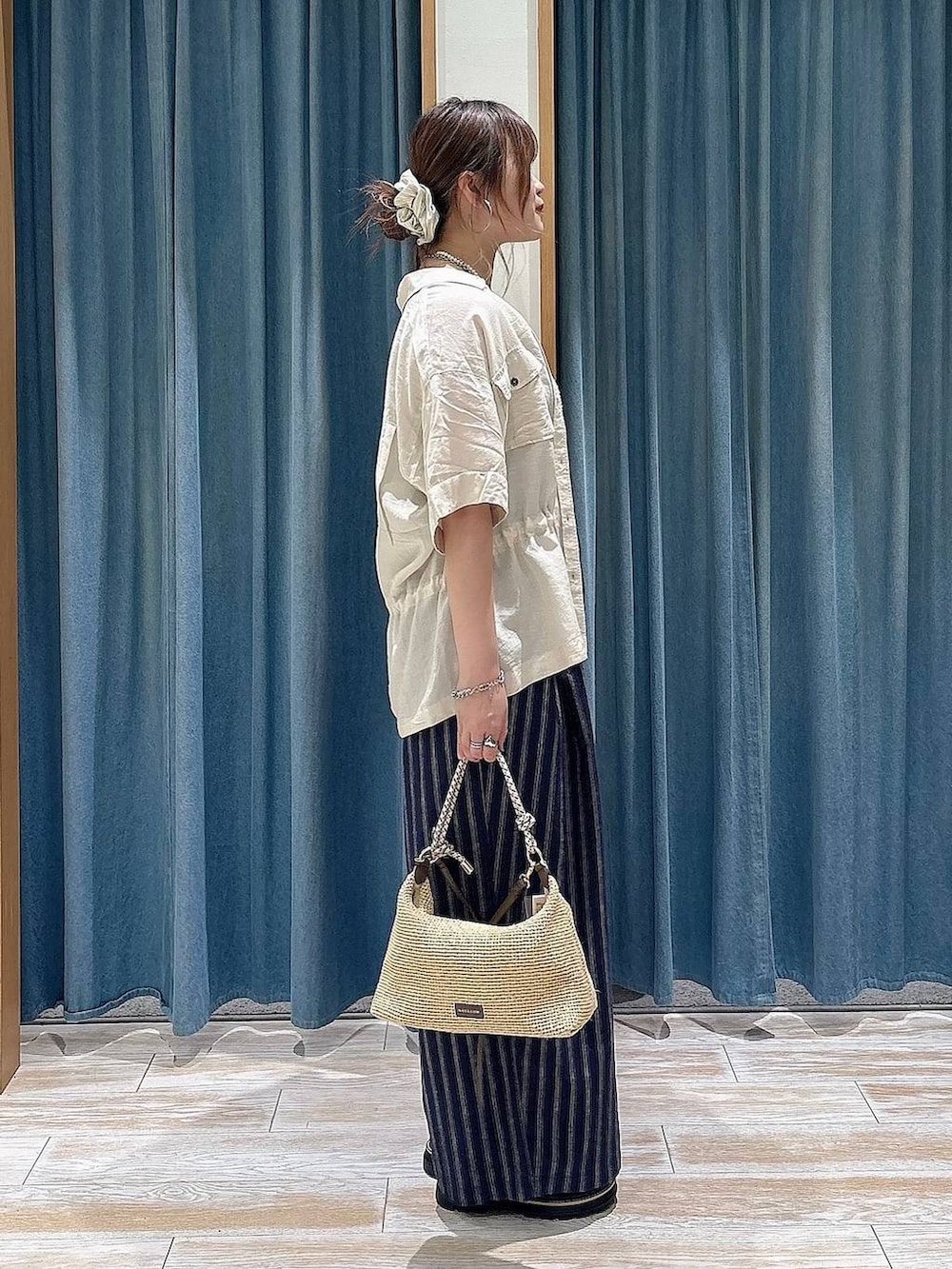 ブラック系のキャミソール、ブルー系のその他パンツ、ベージュ系のショルダーバッグを着用したレディースの春コーディネートの2枚目の写真