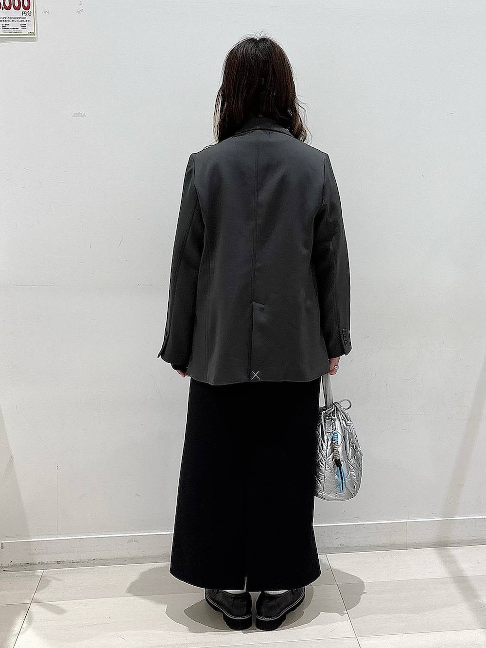 シルバー系のハンドバッグ、ブラック系のTシャツ/カットソー、ブラック系のスカートを着用したレディースの春コーディネートの3枚目の写真