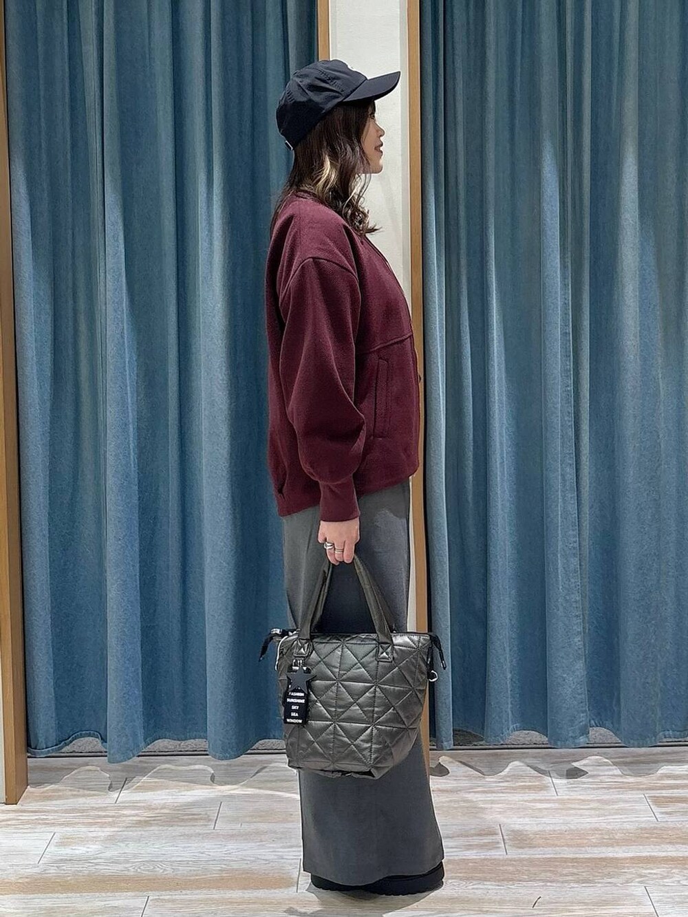 グレー系のその他パンツ、レッド系のブルゾン、ブラック系のブーツを着用したレディースの冬コーディネートの2枚目の写真