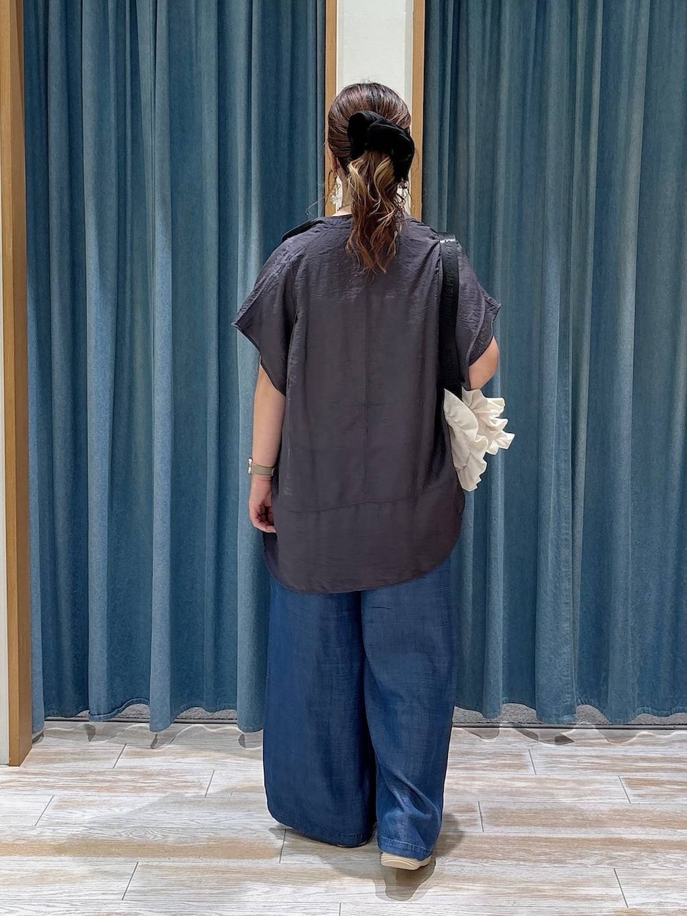 ブルー系のデニムパンツ、グレー系のシャツ/ブラウス、シルバー系のサンダルを着用したレディースの夏コーディネートの3枚目の写真