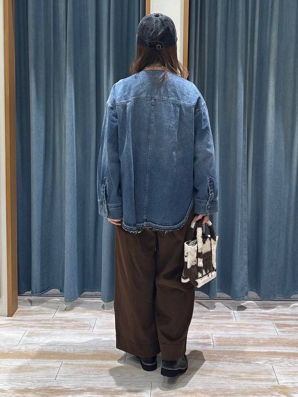 ブラウン系のその他パンツ、ブルー系のシャツ/ブラウス、ブラウン系のトートバッグを着用したレディースの秋コーディネートの3枚目の写真