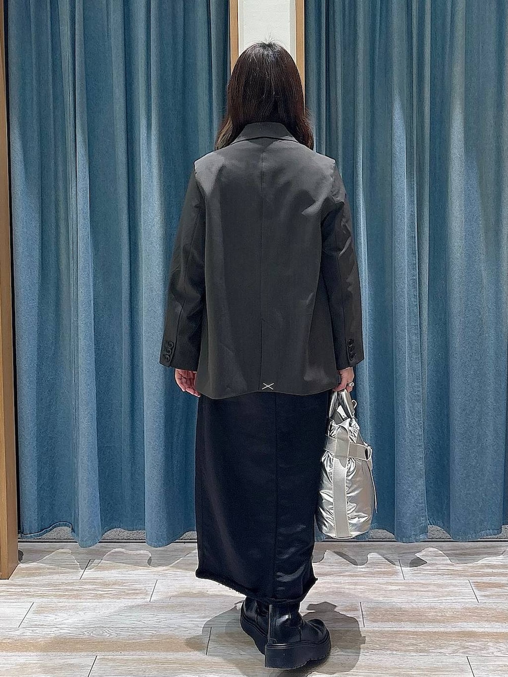 シルバー系のトートバッグ、ブラック系のブーツ、ブラック系のTシャツ/カットソーを着用したレディースの冬コーディネートの3枚目の写真