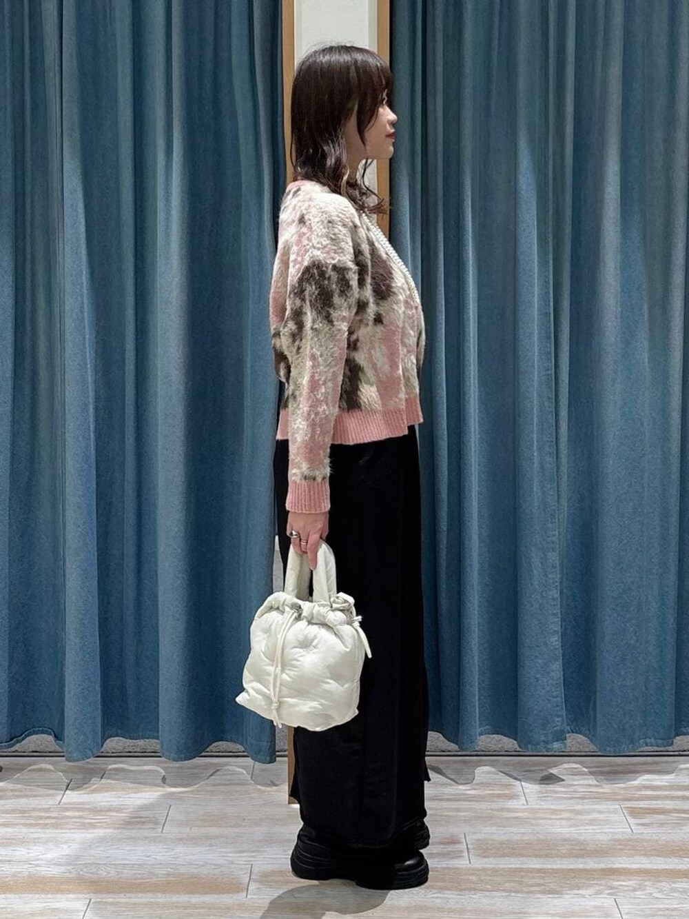 ブラック系のブーツ、ブラック系のスカート、ピンク系のニット/セーターを着用したレディースの冬コーディネートの2枚目の写真