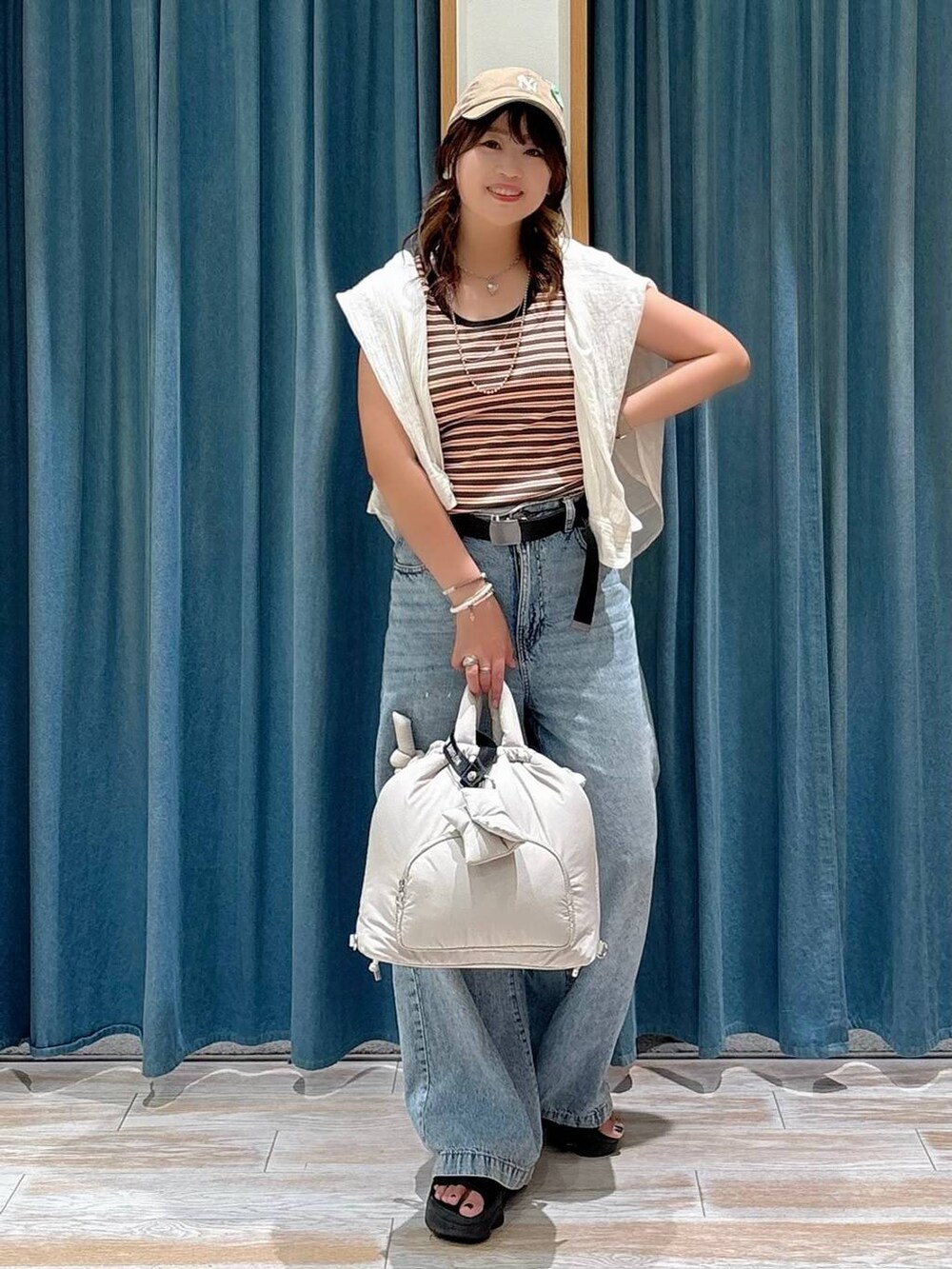 ホワイト系のシャツ/ブラウス、ブルー系のデニムパンツ、ホワイト系のトートバッグを着用したレディースの夏コーディネートの3枚目の写真