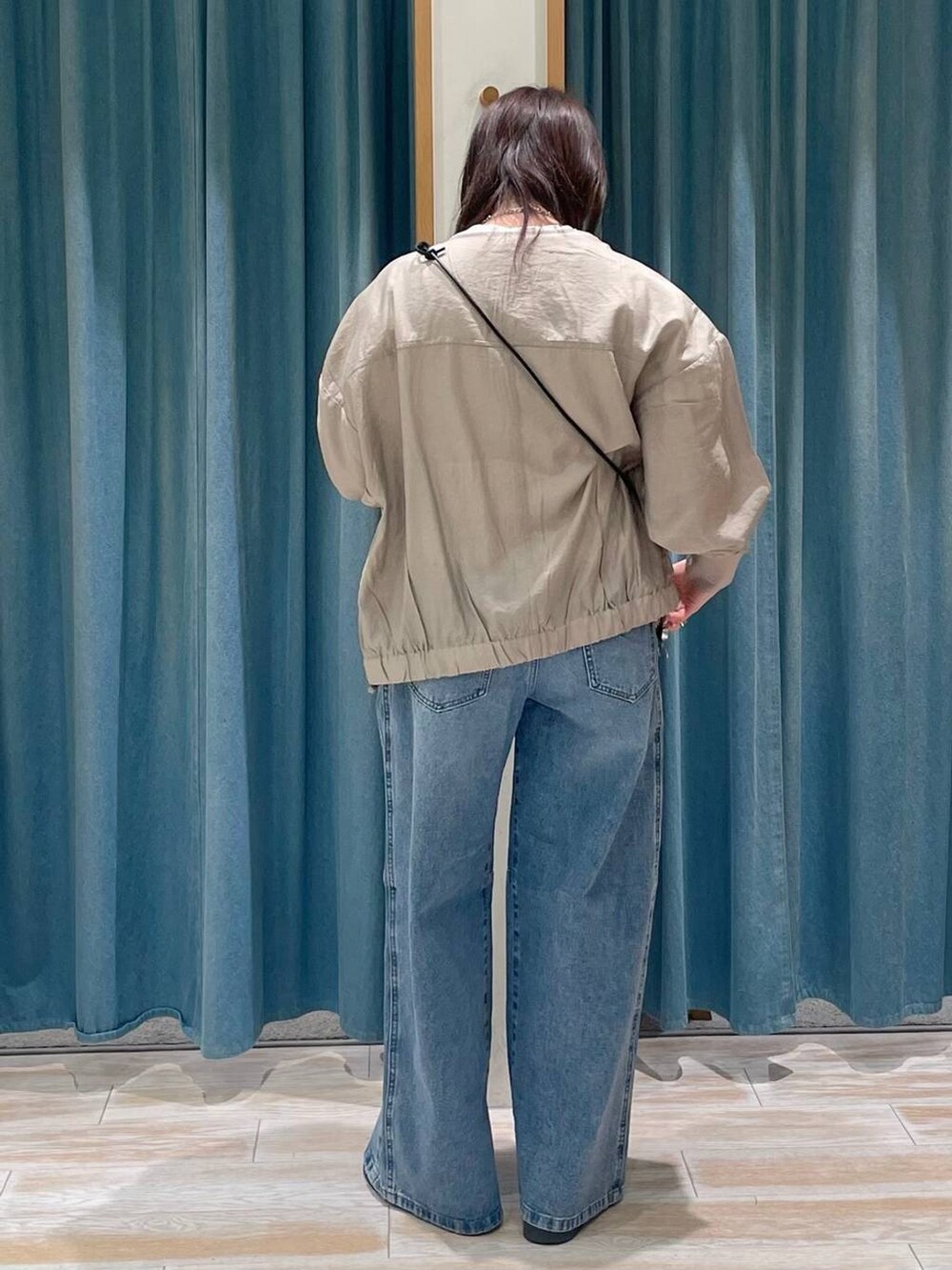 ベージュ系のショルダーバッグ、ブルー系のデニムパンツ、ホワイト系のTシャツ/カットソーを着用したレディースの春コーディネートの3枚目の写真