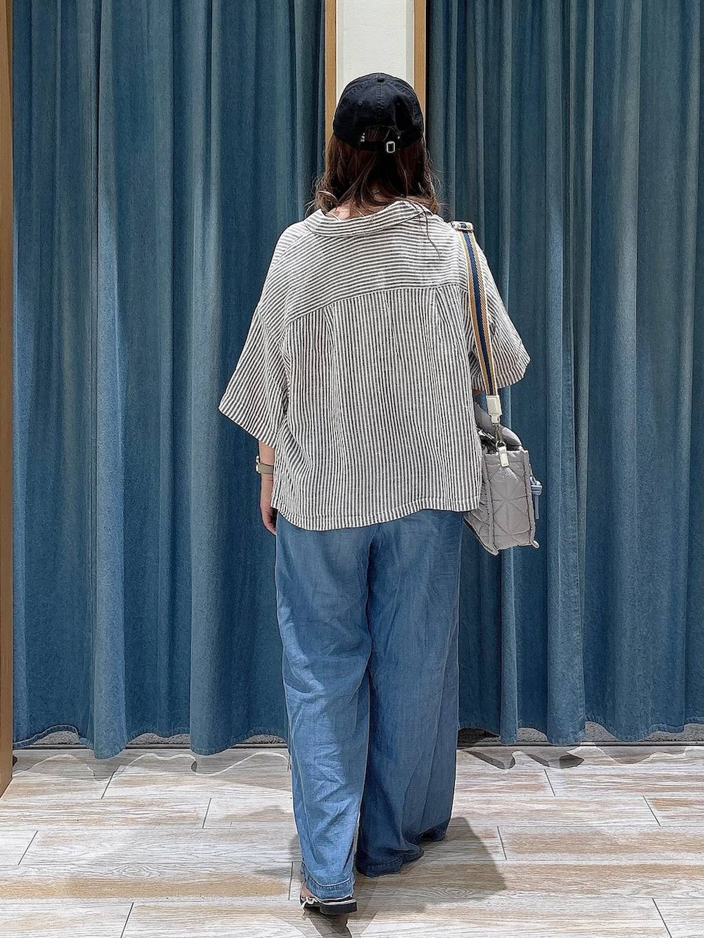 グレー系のショルダーバッグ、ブルー系のデニムパンツ、グレー系のシャツ/ブラウスを着用したレディースの春コーディネートの3枚目の写真