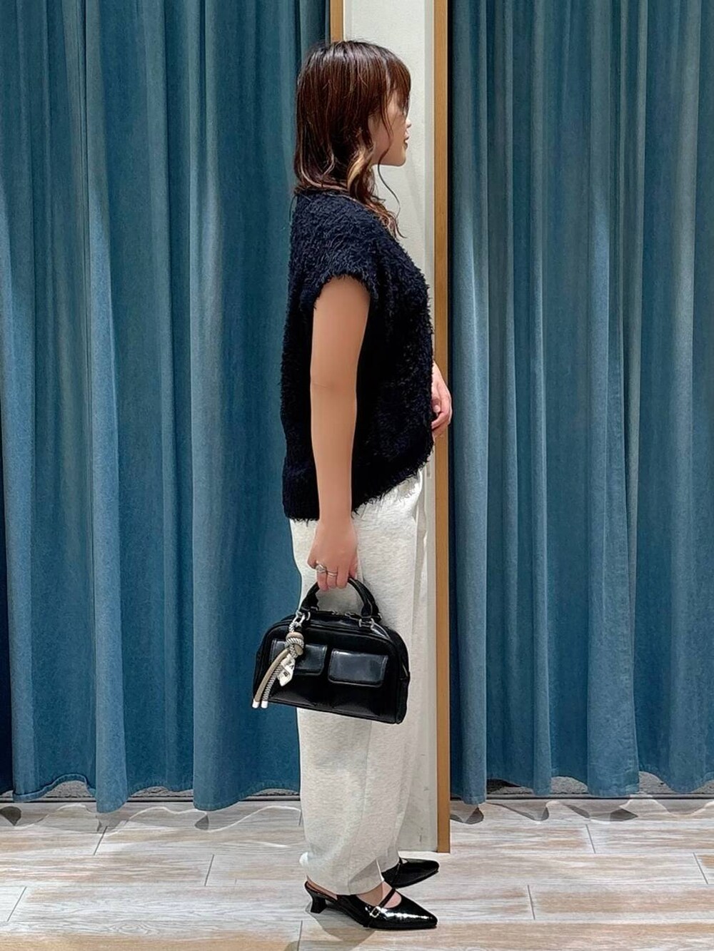 ブラック系のその他シューズ、ブラック系のボストンバッグ、ベージュ系のその他パンツを着用したレディースの夏コーディネートの2枚目の写真