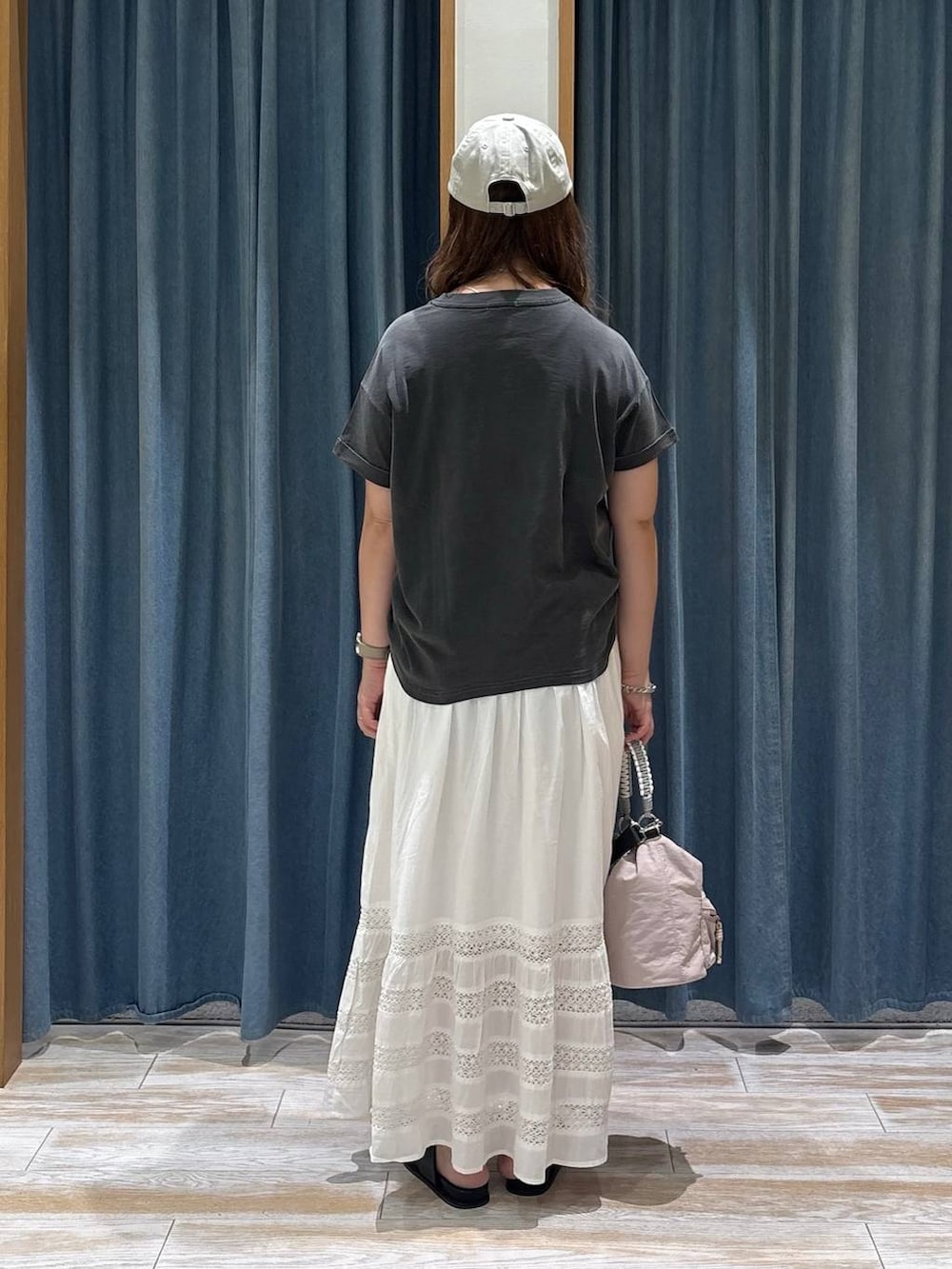 グレー系のTシャツ/カットソー、ホワイト系のスカート、ピンク系のショルダーバッグを着用したレディースの夏コーディネートの2枚目の写真