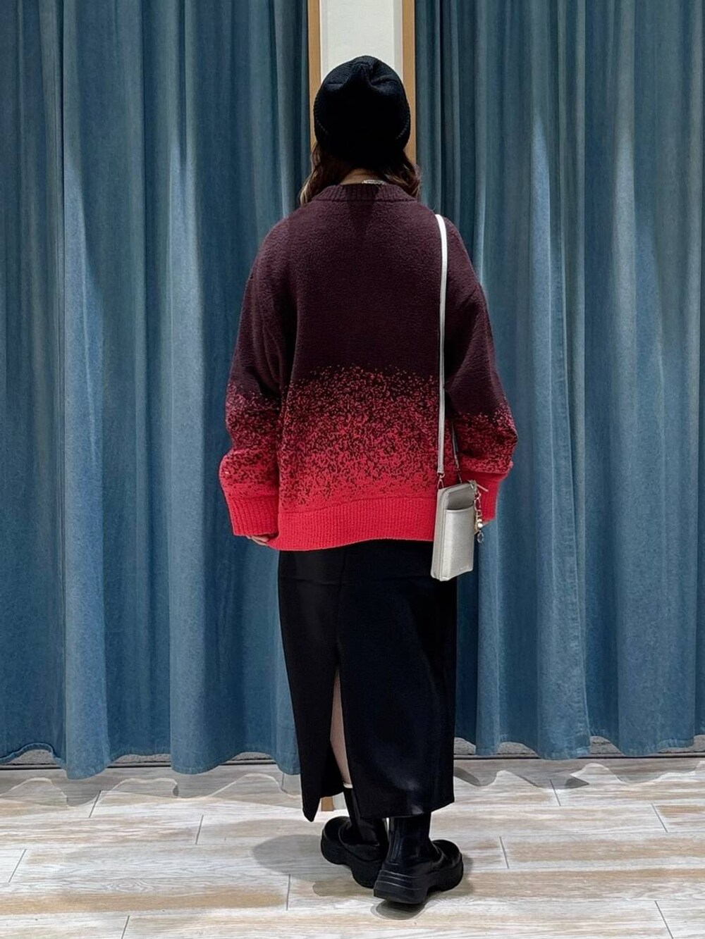 ブラック系のブーツ、ブラック系のスカート、ピンク系のニット/セーターを着用したレディースの秋コーディネートの3枚目の写真