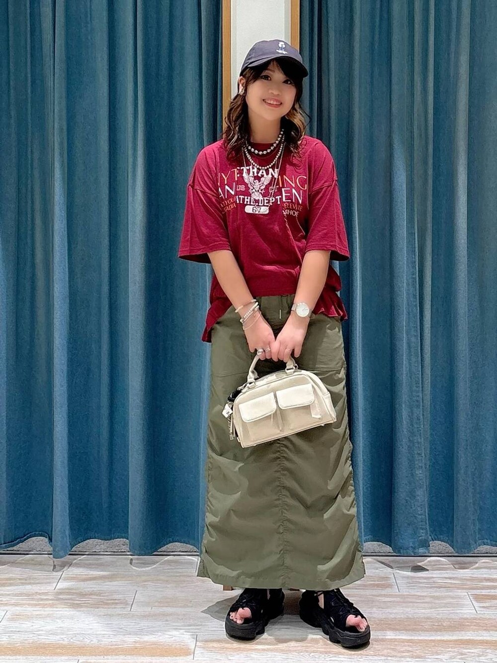 グリーン系のスカート、ホワイト系のボストンバッグ、シルバー系のネックレスを着用したレディースの夏コーディネートの4枚目の写真