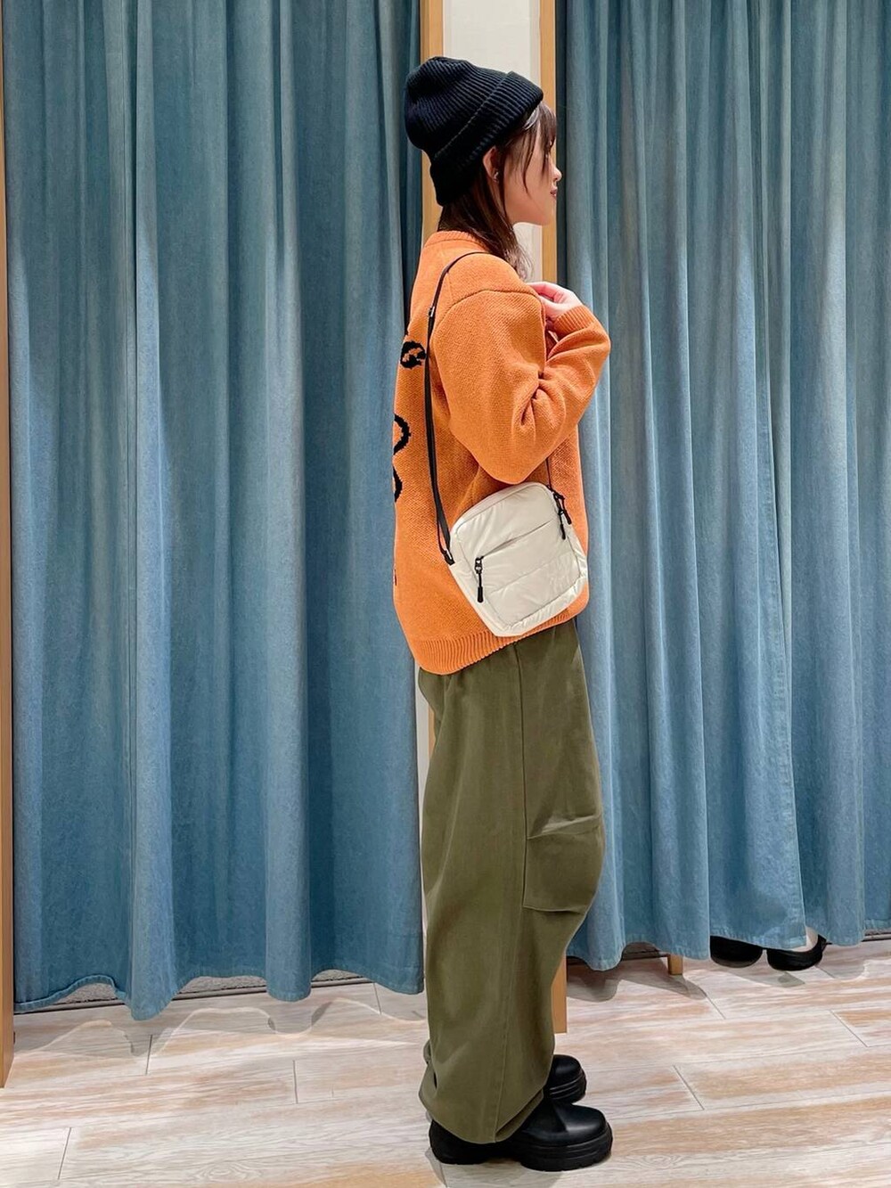 グリーン系のその他パンツ、ブラック系のブーツ、ベージュ系のショルダーバッグを着用したレディースの冬コーディネートの3枚目の写真