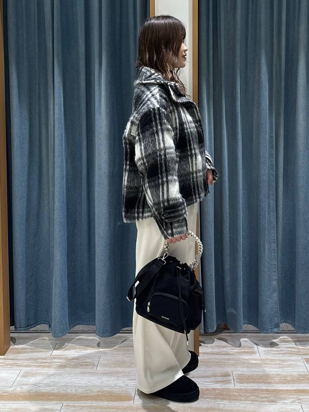 ベージュ系のその他パンツ、ブラック系のブーツ、ブラック系のハンドバッグを着用したレディースの冬コーディネートの2枚目の写真