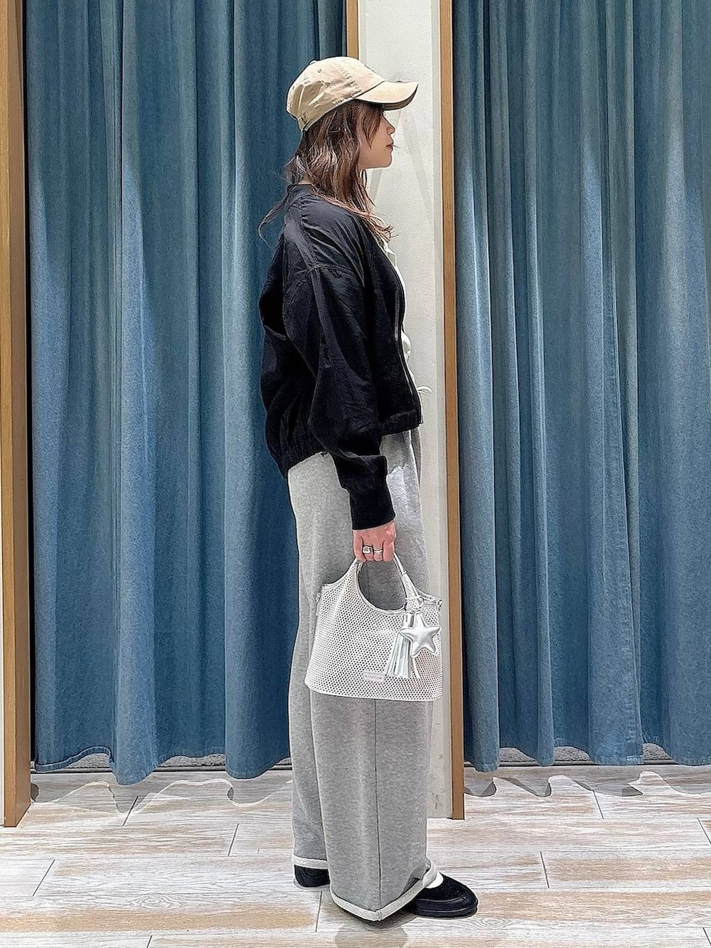 ブラック系のバレエシューズ、グレー系のショルダーバッグ、グリーン系のカーディガン/ボレロを着用したレディースの春コーディネートの2枚目の写真