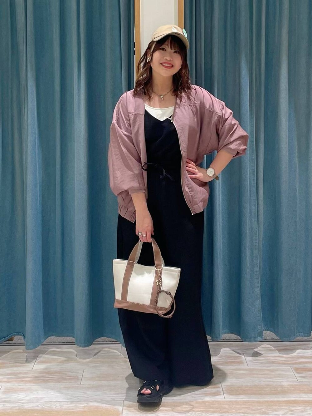 ホワイト系のキャミソール、ブラウン系のトートバッグ、ブラック系のサロペット/オーバーオールを着用したレディースの春コーディネートの4枚目の写真