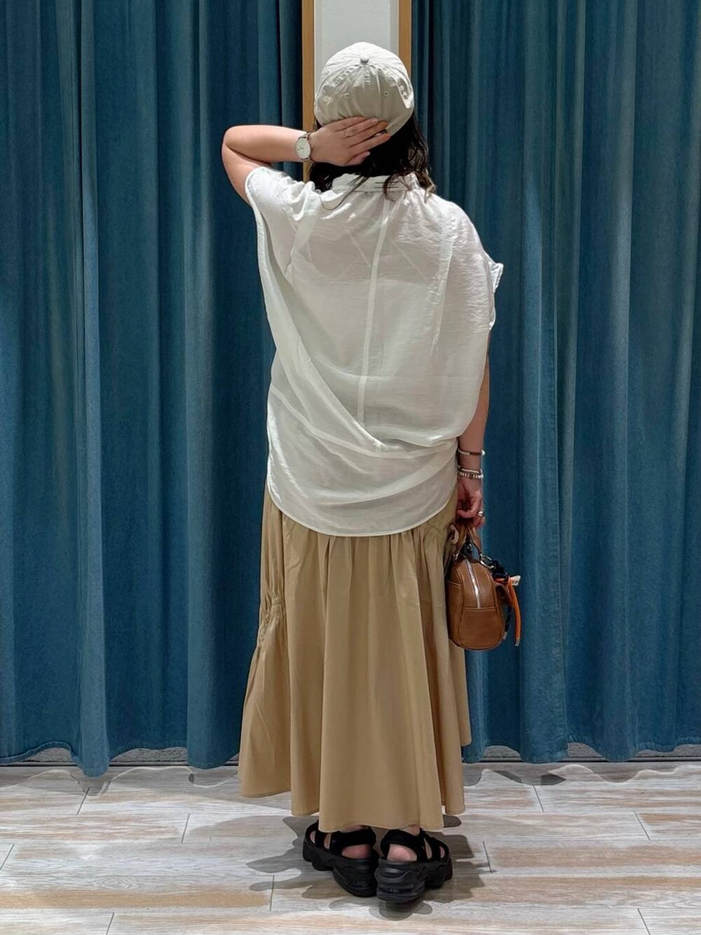 ホワイト系のキャミソール、ホワイト系のシャツ/ブラウス、ブラウン系のボストンバッグを着用したレディースの夏コーディネートの3枚目の写真