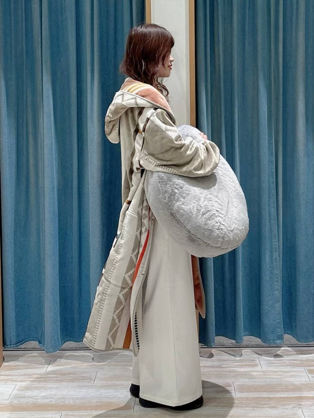 ベージュ系のその他パンツ、ブラック系のブーツ、グレー系のクッション/クッションカバーを着用したレディースの秋コーディネートの2枚目の写真