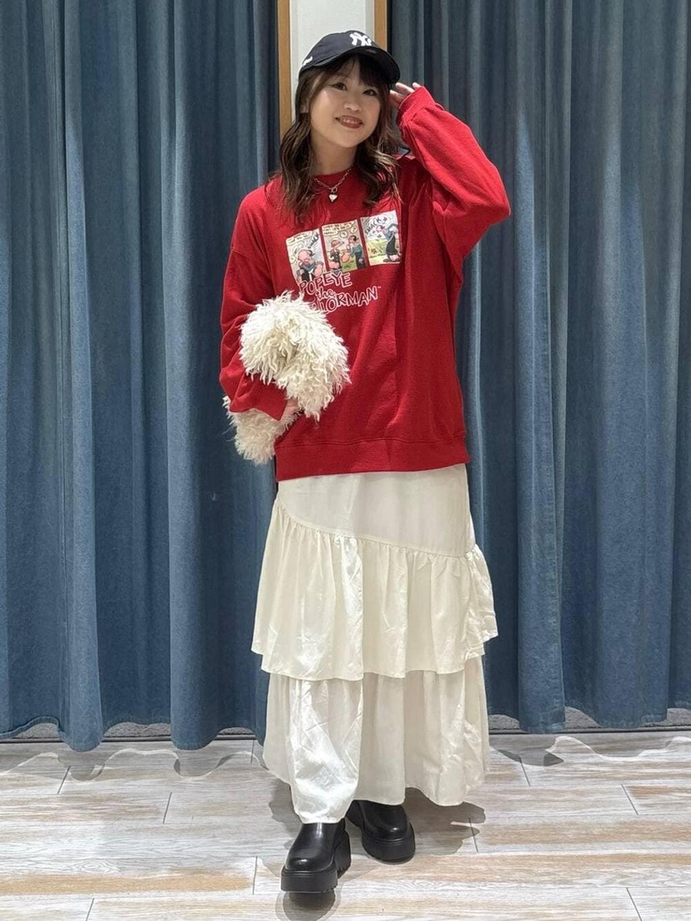 ブラック系のブーツ、ベージュ系のスカート、ベージュ系のショルダーバッグを着用したレディースの冬コーディネートの4枚目の写真