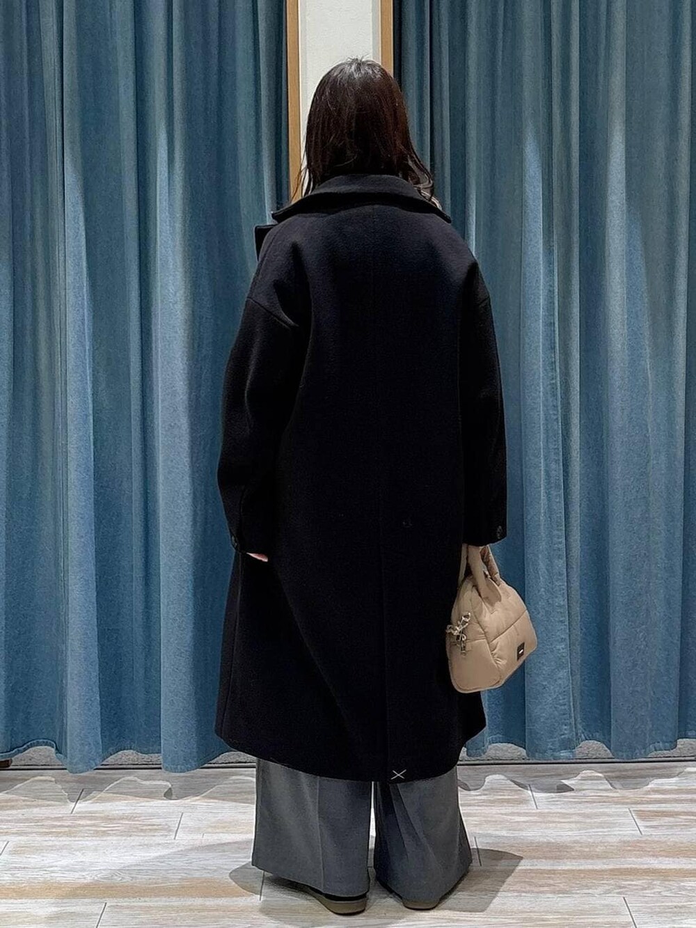 グレー系のその他パンツ、ブラック系のチェスターコート、ブラック系のスニーカーを着用したレディースの冬コーディネートの3枚目の写真