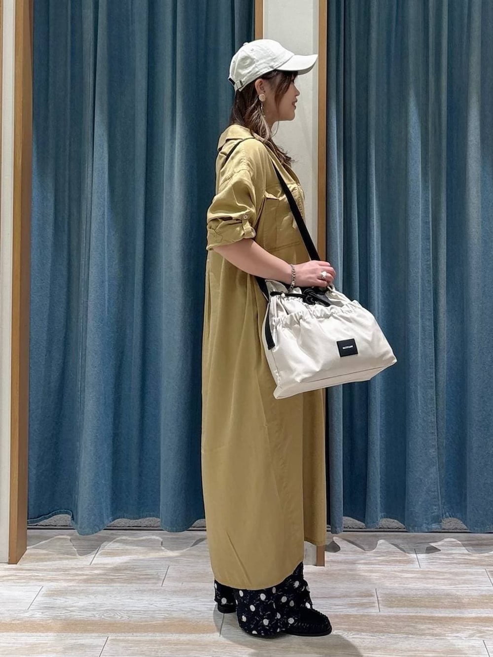 ホワイト系のトートバッグ、ブラック系のタンクトップ、ブラック系のローファーを着用したレディースの春コーディネートの2枚目の写真