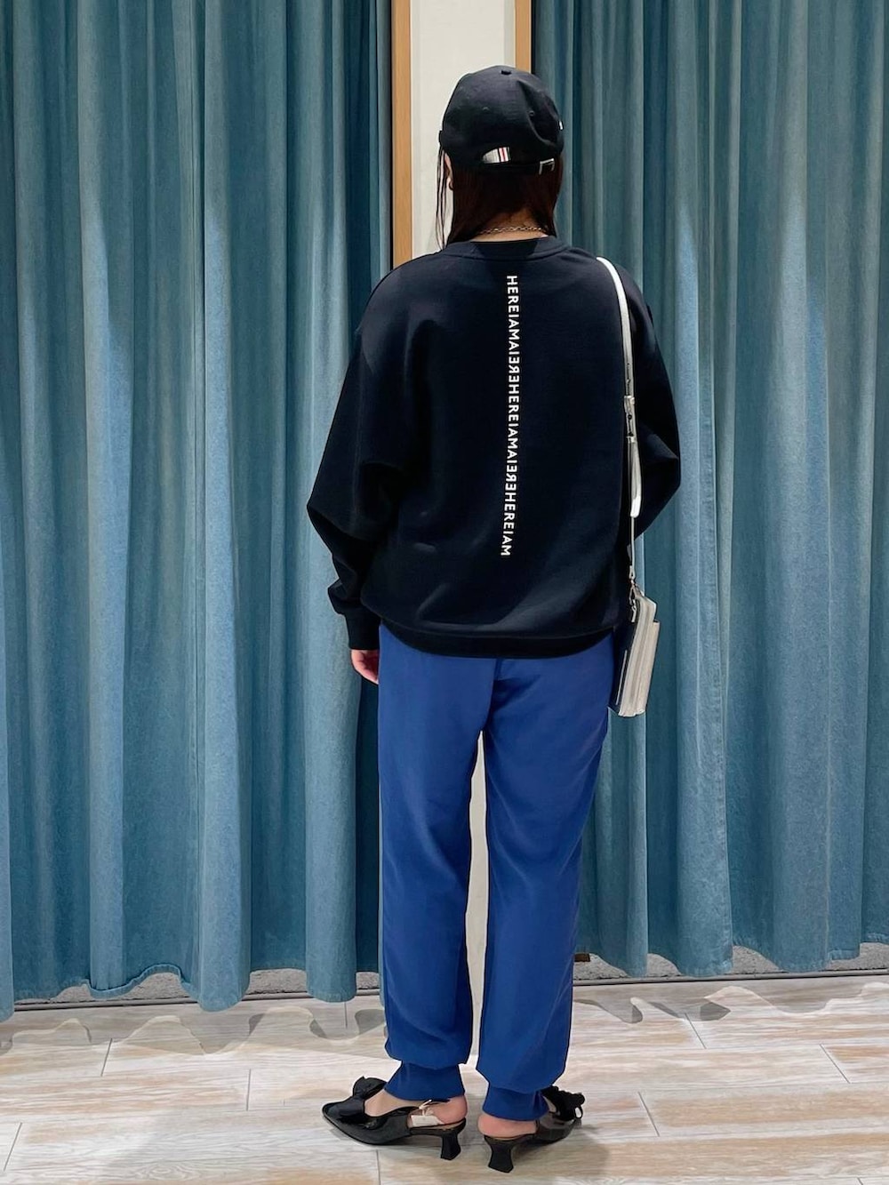 ブルー系のその他パンツ、ブラック系のスウェット、ブラック系のパンプスを着用したレディースの冬コーディネートの3枚目の写真