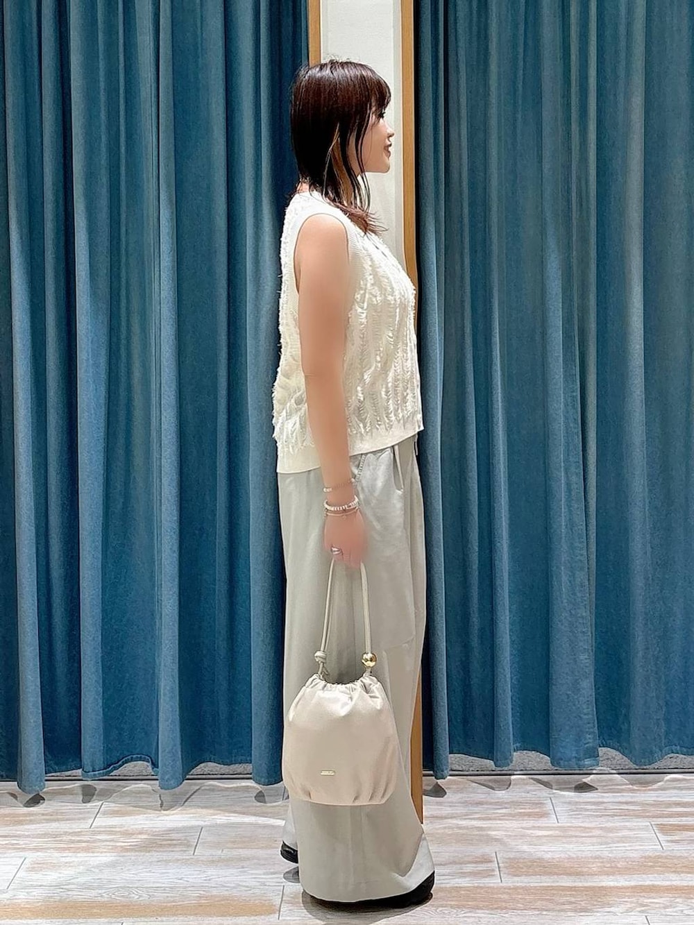 ベージュ系のその他パンツ、ホワイト系のショルダーバッグ、ホワイト系のベストを着用したレディースの夏コーディネートの2枚目の写真