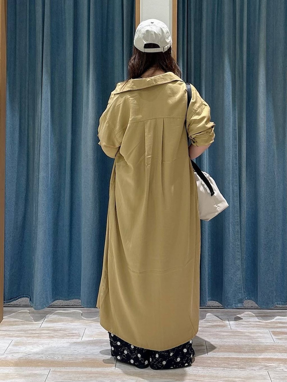 ホワイト系のトートバッグ、ブラック系のタンクトップ、ブラック系のローファーを着用したレディースの春コーディネートの3枚目の写真