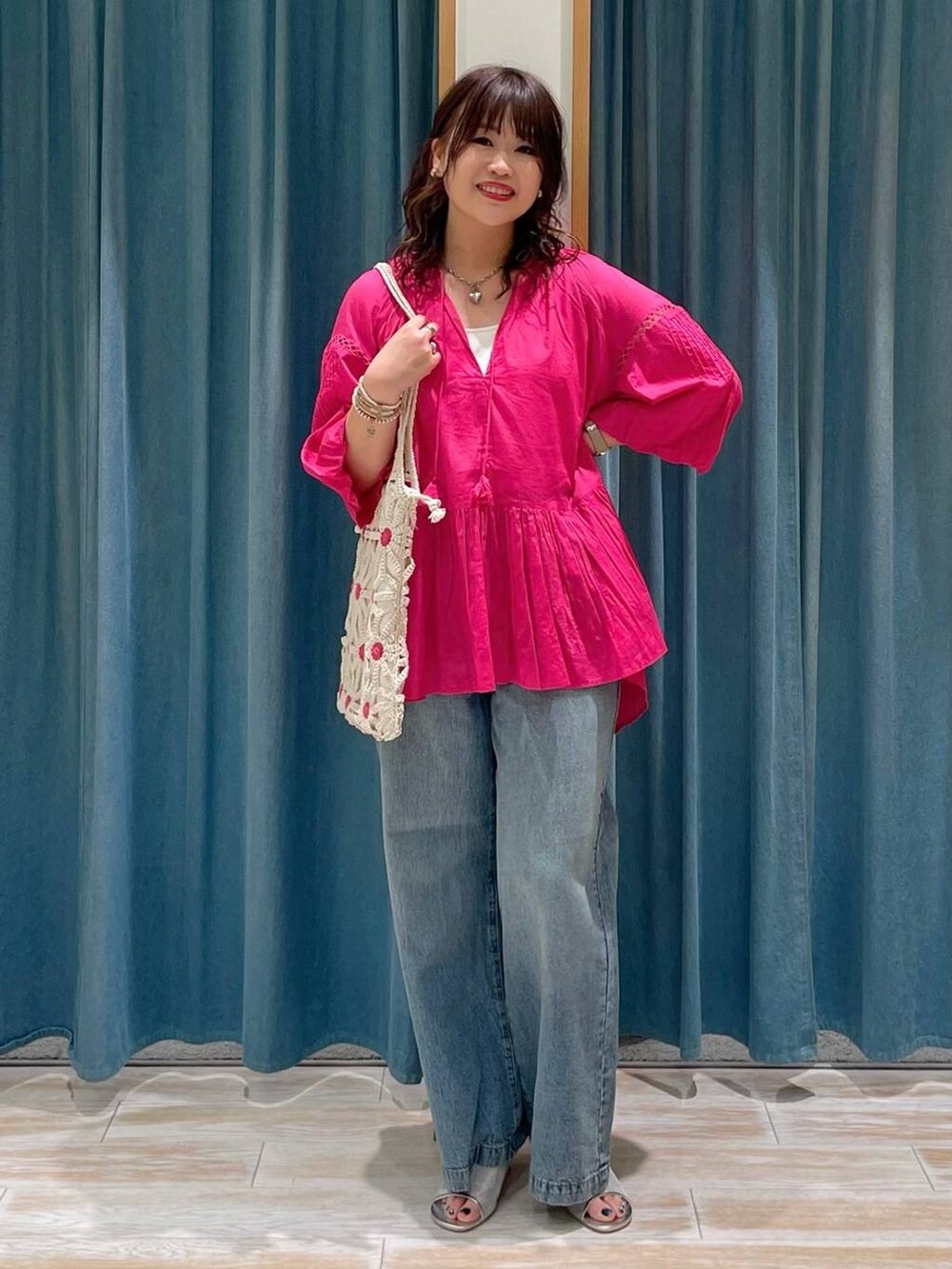 ホワイト系のキャミソール、シルバー系のサンダル、ブルー系のデニムパンツを着用したレディースの春コーディネートの4枚目の写真