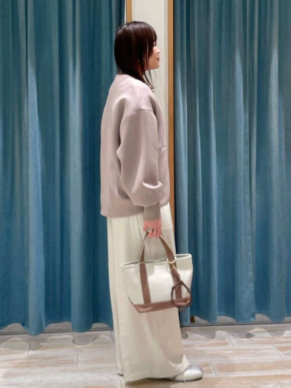 ホワイト系のその他パンツ、ブラウン系のトートバッグ、ホワイト系のスニーカーを着用したレディースの冬コーディネートの2枚目の写真