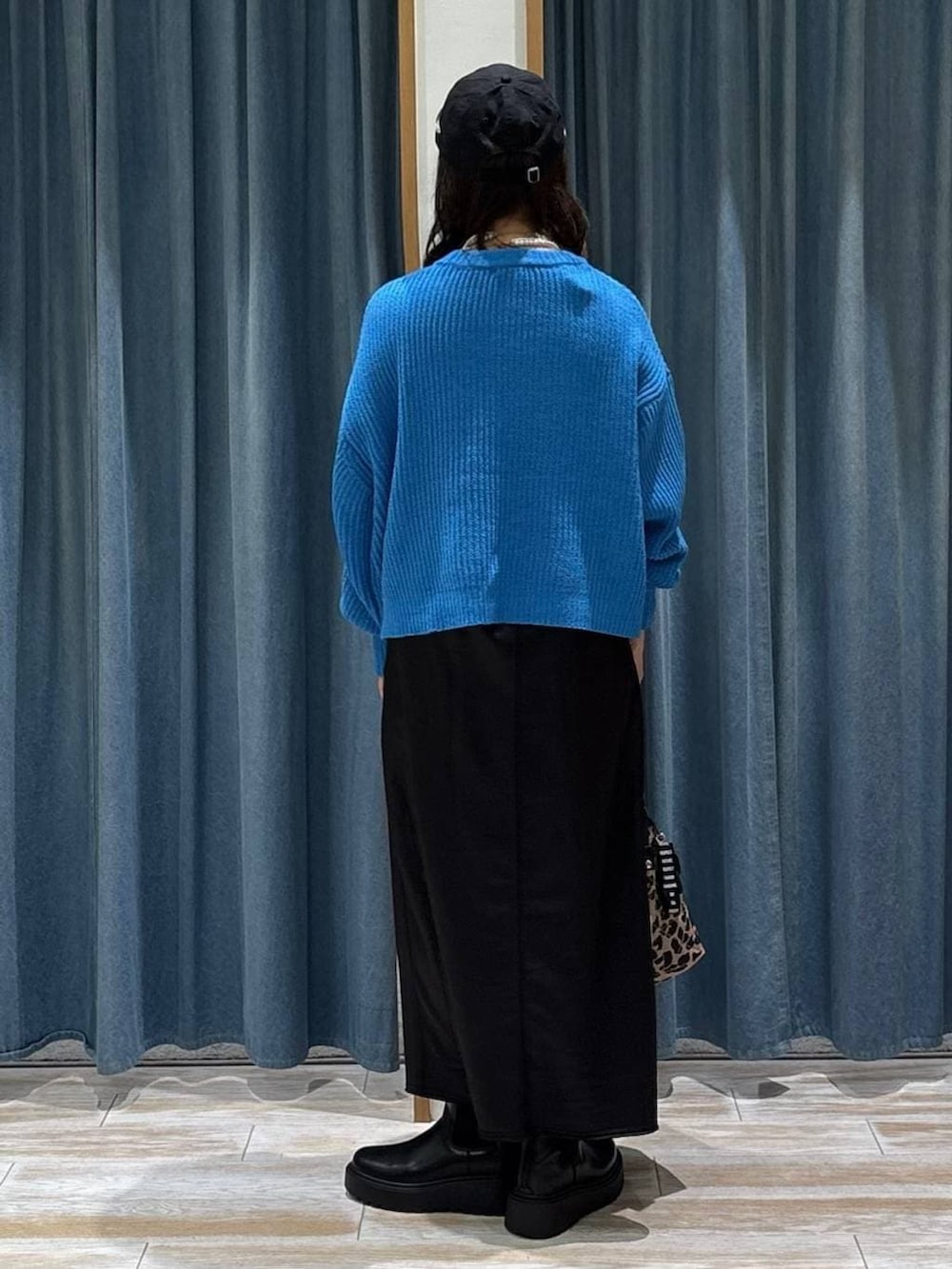 ブラック系のブーツ、ブラック系のスカート、その他のトートバッグを着用したレディースの冬コーディネートの3枚目の写真