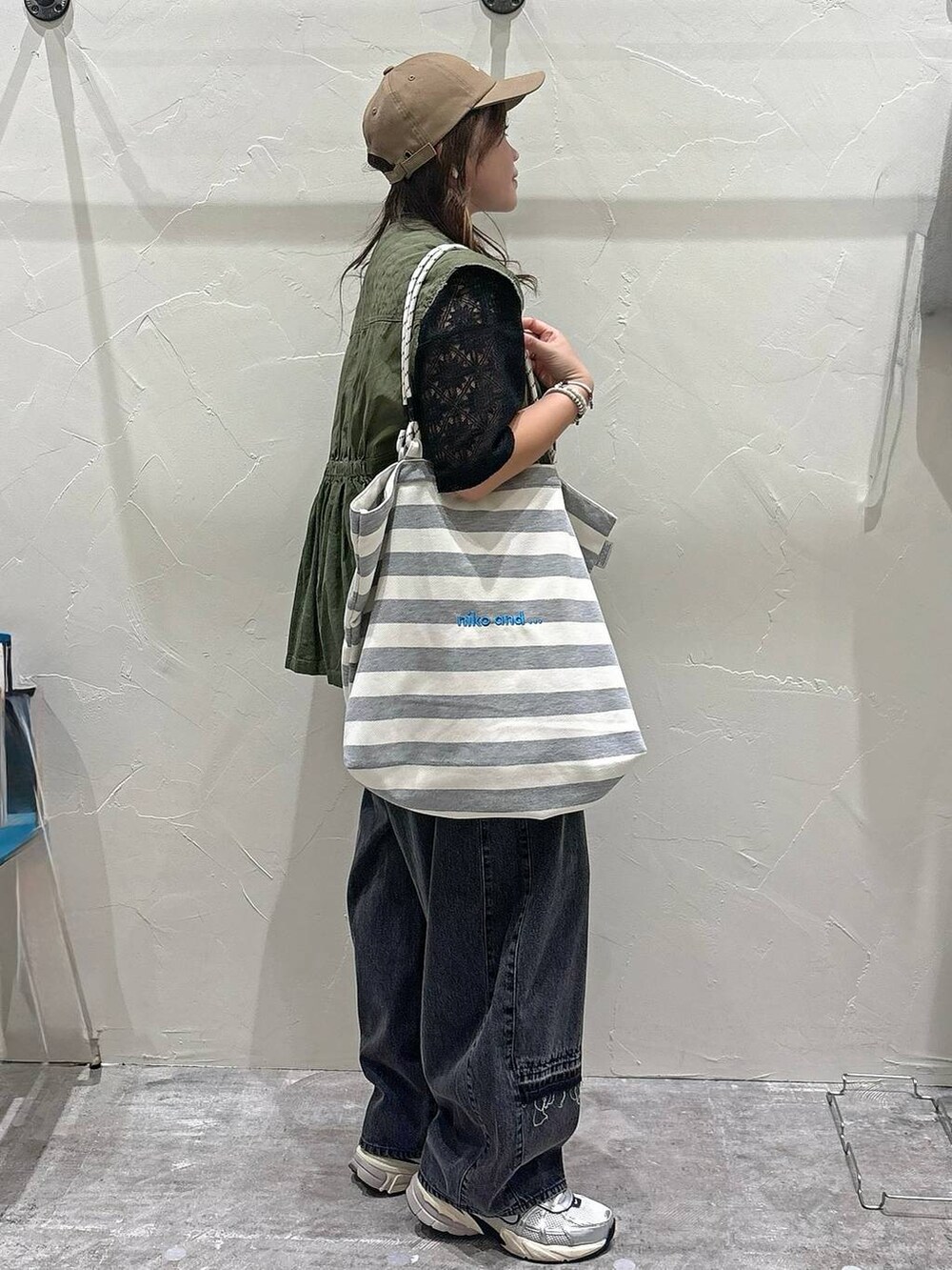 ホワイト系のトートバッグ、ブラック系のTシャツ/カットソー、グレー系のデニムパンツを着用したレディースの夏コーディネートの2枚目の写真