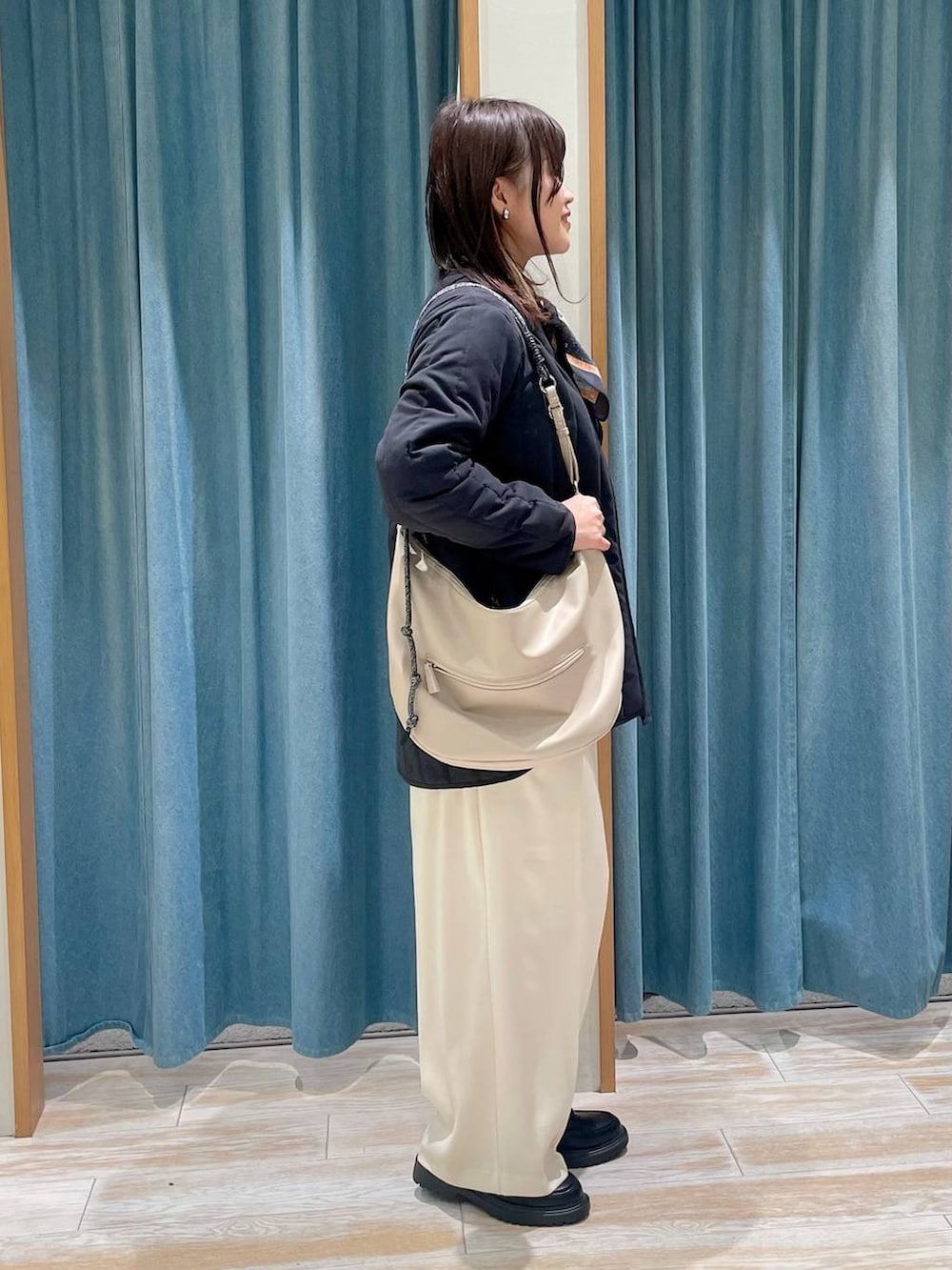 ホワイト系のニット/セーター、ブラック系のその他アウター、ベージュ系のその他パンツを着用したレディースの冬コーディネートの2枚目の写真