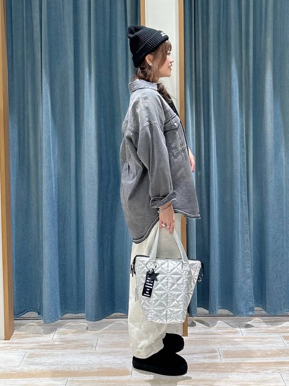 ブラック系のシャツ/ブラウス、ブラック系のブーツ、シルバー系のトートバッグを着用したレディースの秋コーディネートの2枚目の写真