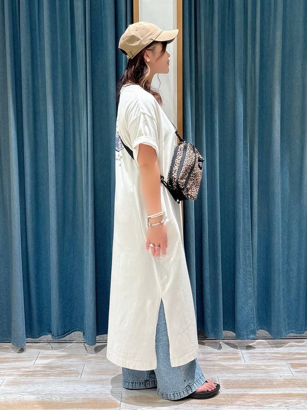 その他のショルダーバッグ、ブルー系のデニムパンツ、ベージュ系のワンピースを着用したレディースの夏コーディネートの2枚目の写真