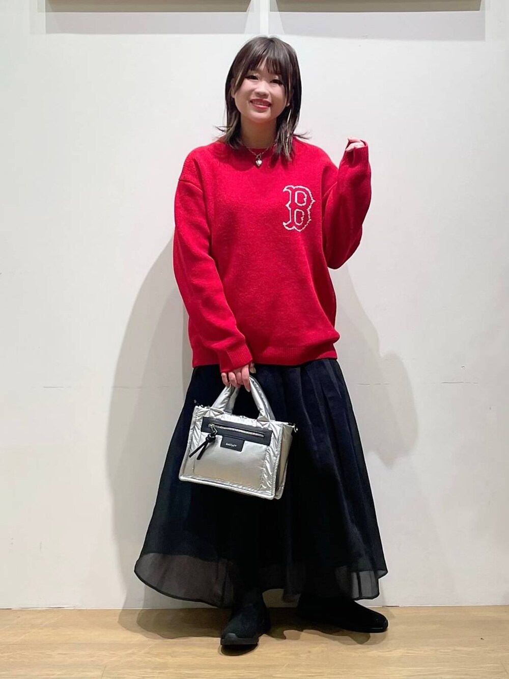 シルバー系のショルダーバッグ、ブラック系のブーツ、レッド系のニット/セーターを着用したレディースの秋コーディネートの4枚目の写真