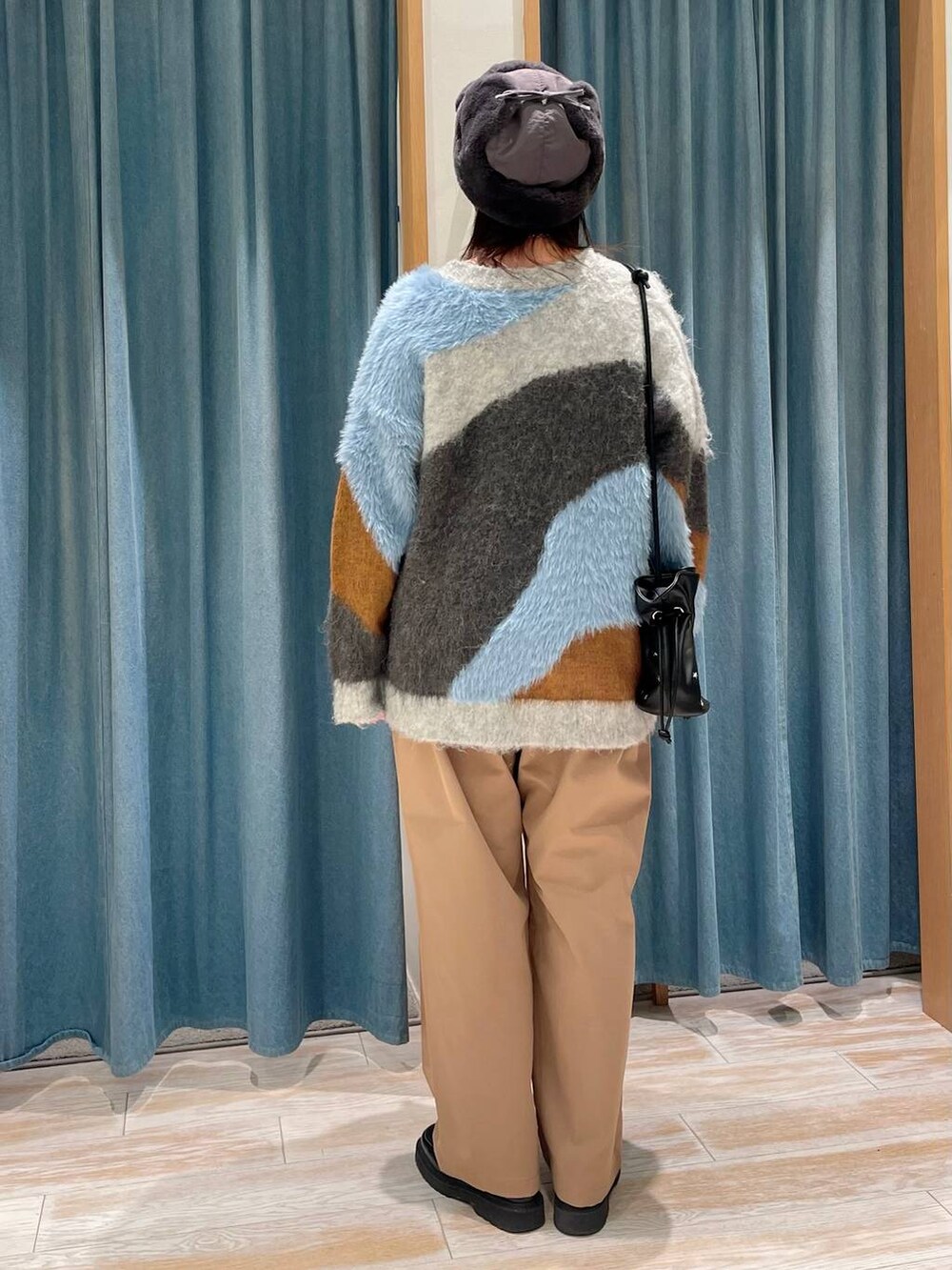 ブラック系のショルダーバッグ、ベージュ系のその他パンツ、グレー系のカーディガン/ボレロを着用したレディースの冬コーディネートの3枚目の写真