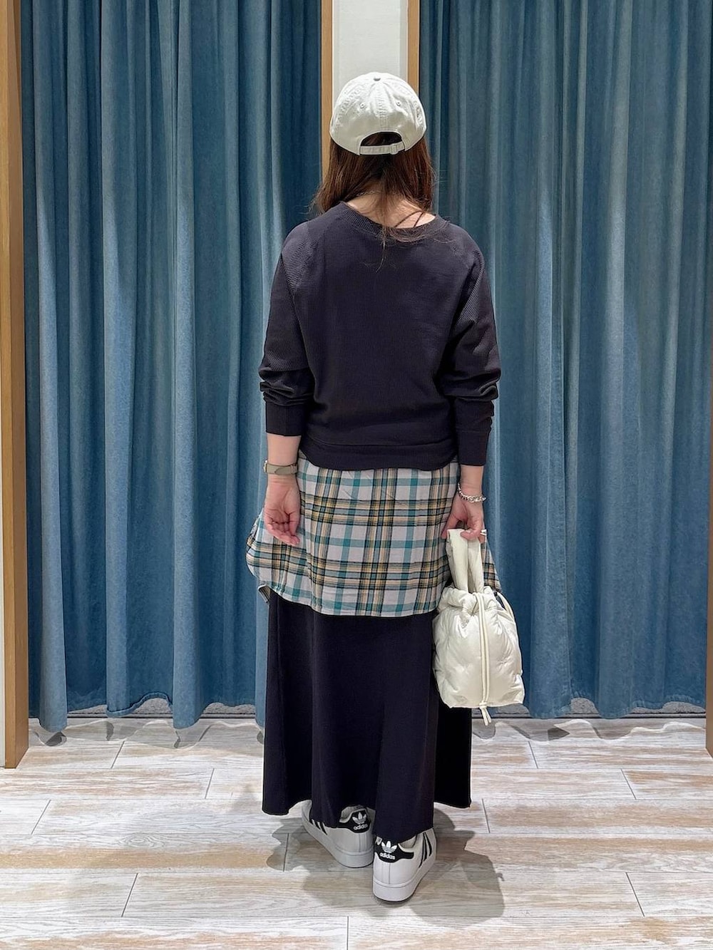 グレー系のTシャツ/カットソー、グレー系のスカート、ホワイト系のスニーカーを着用したレディースの秋コーディネートの3枚目の写真