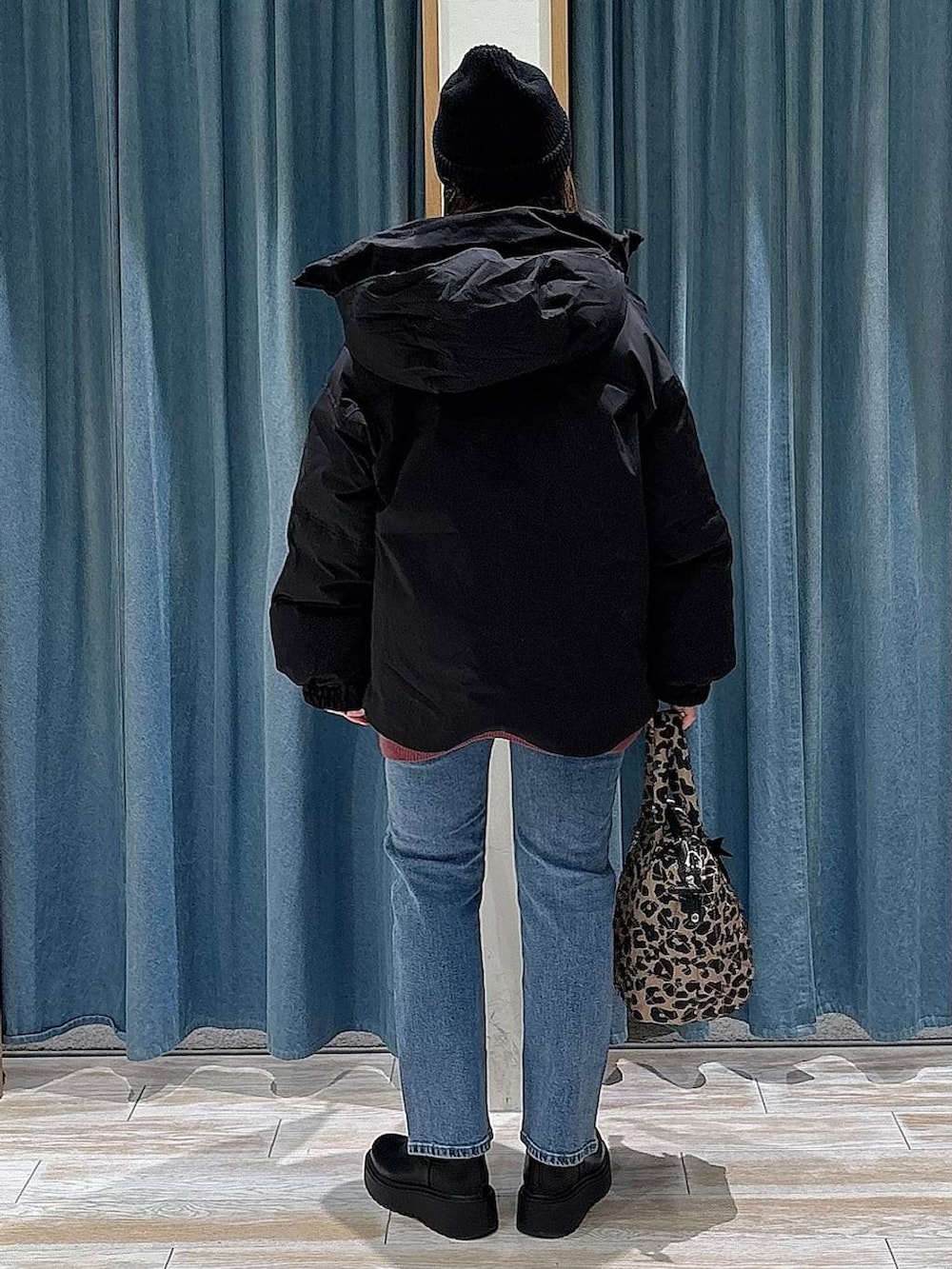 ブラック系のブーツ、ブラック系のダウンジャケット/コート、ピンク系のニット/セーターを着用したレディースの冬コーディネートの3枚目の写真