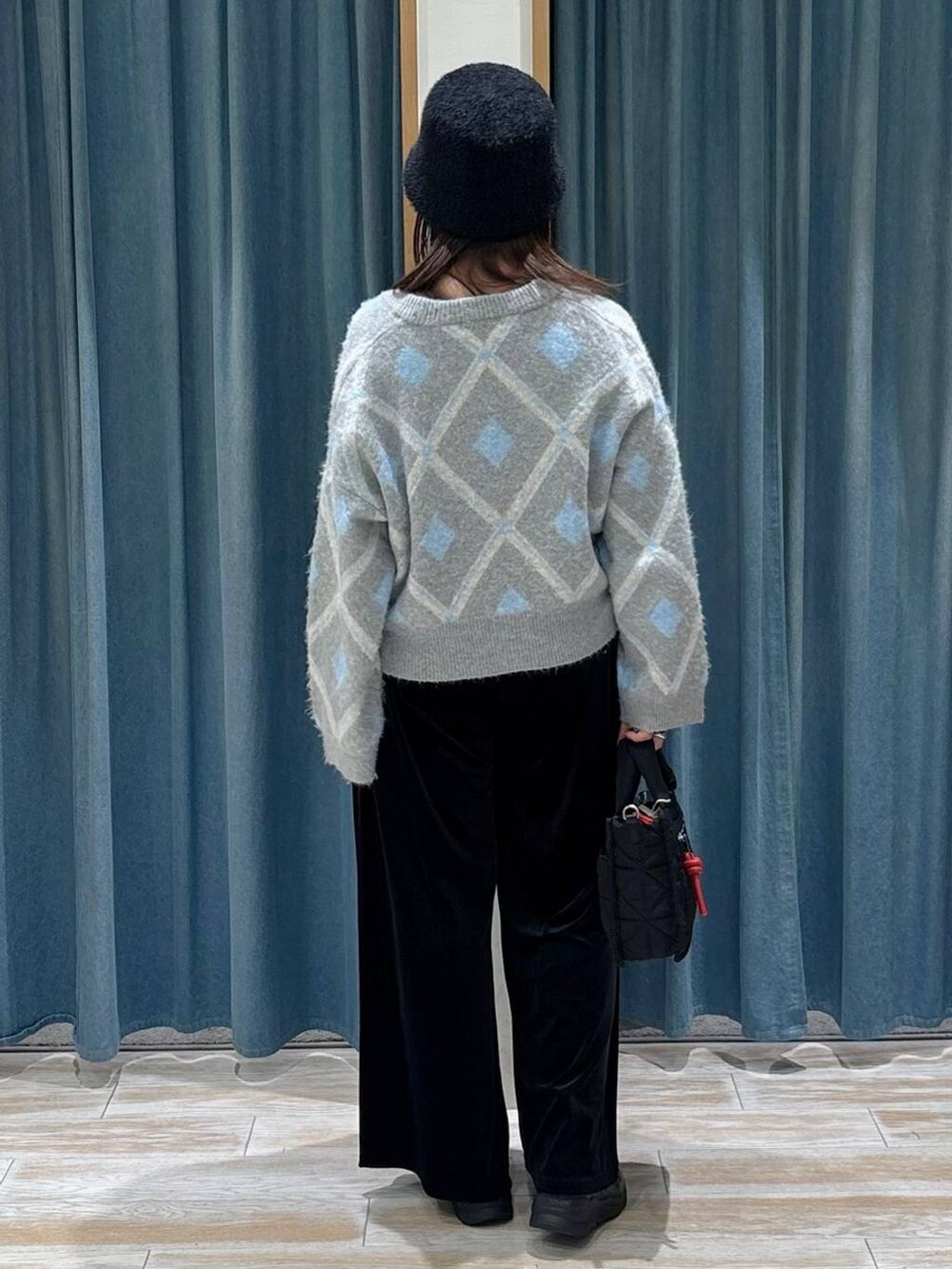 ブラック系のショルダーバッグ、グレー系のカーディガン/ボレロ、ブラック系のブーツを着用したレディースの秋コーディネートの3枚目の写真