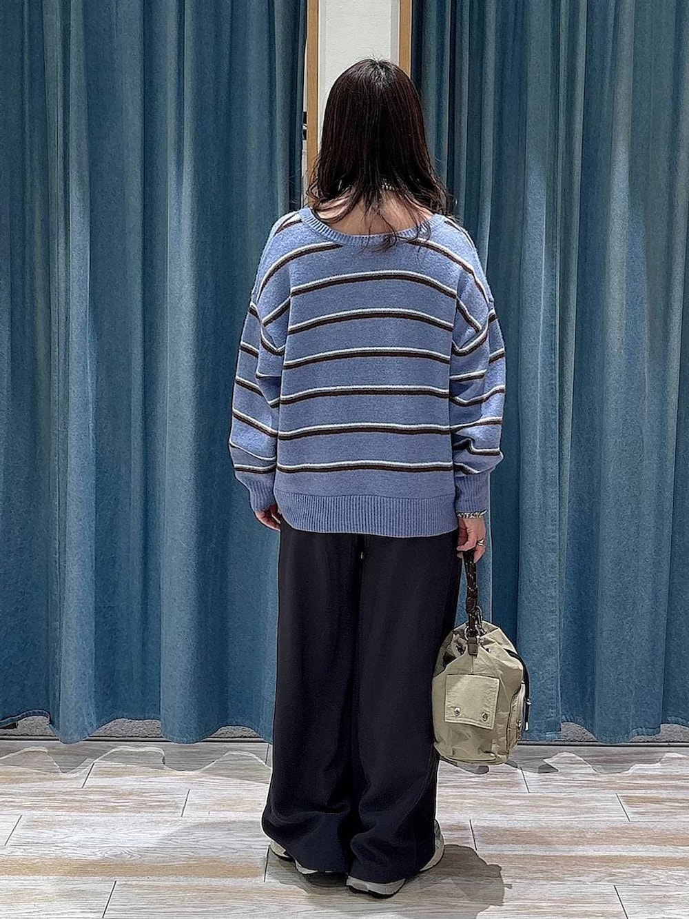 ベージュ系のハンドバッグ、ブルー系のニット/セーター、グレー系のその他パンツを着用したレディースの冬コーディネートの3枚目の写真