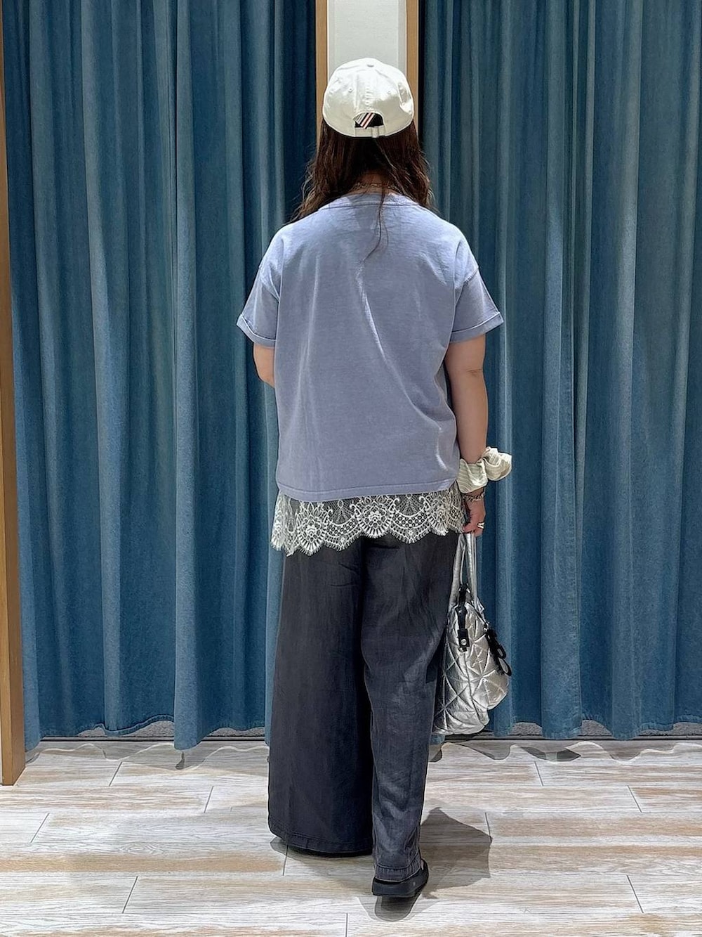 ブラック系のデニムパンツ、ブルー系のTシャツ/カットソー、ブラック系のサンダルを着用したレディースの春コーディネートの3枚目の写真