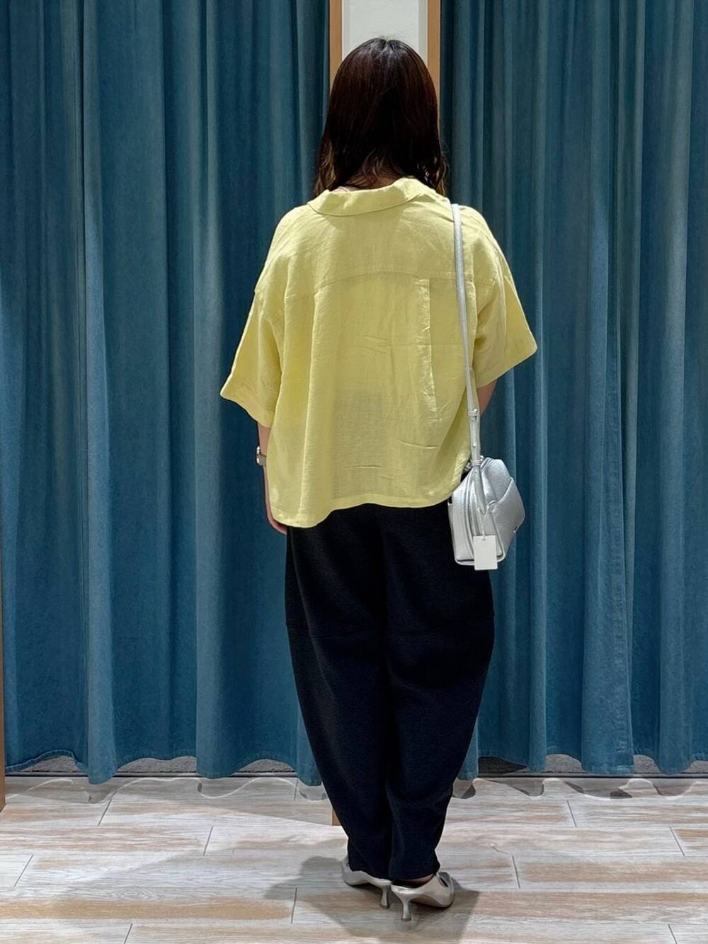 シルバー系のパンプス、ホワイト系のキャミソール、シルバー系のショルダーバッグを着用したレディースの夏コーディネートの3枚目の写真