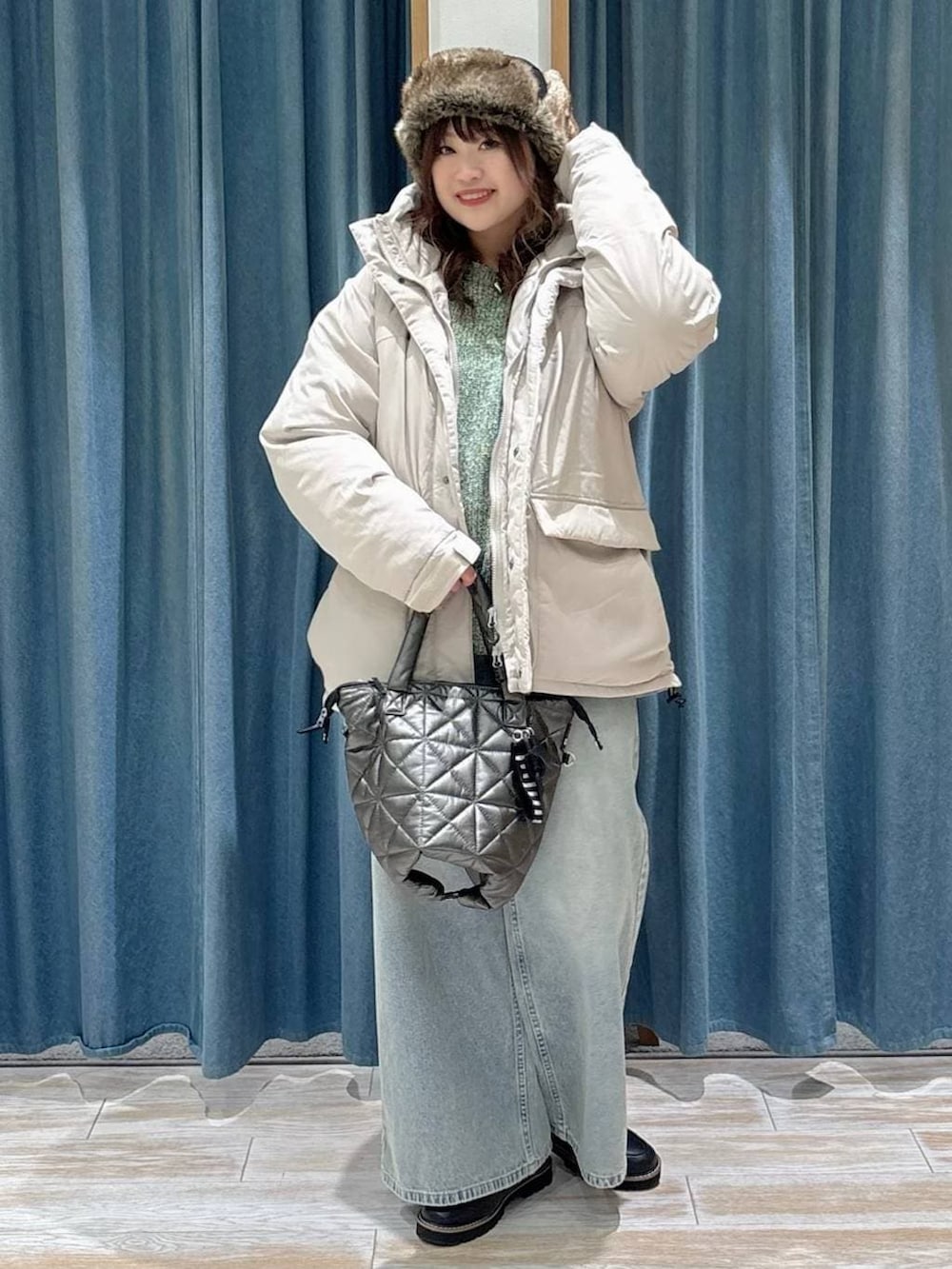 ブラック系のローファー、ベージュ系のダウンジャケット/コート、ブルー系のデニムパンツを着用したレディースの冬コーディネートの4枚目の写真