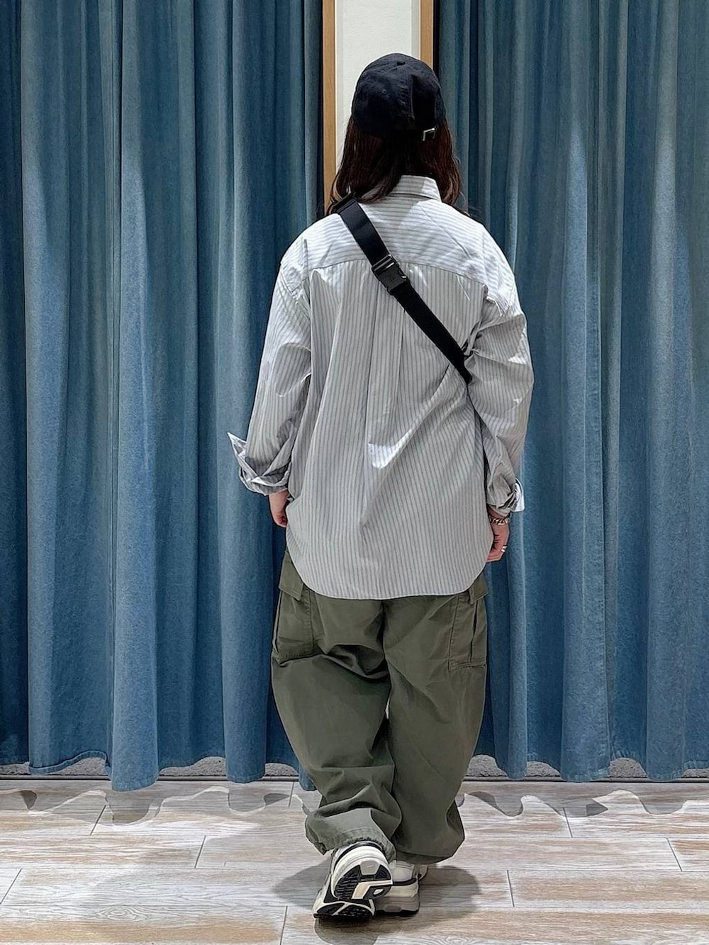 ブラック系のショルダーバッグ、グリーン系のカーゴパンツ、ホワイト系のTシャツ/カットソーを着用したレディースの春コーディネートの3枚目の写真