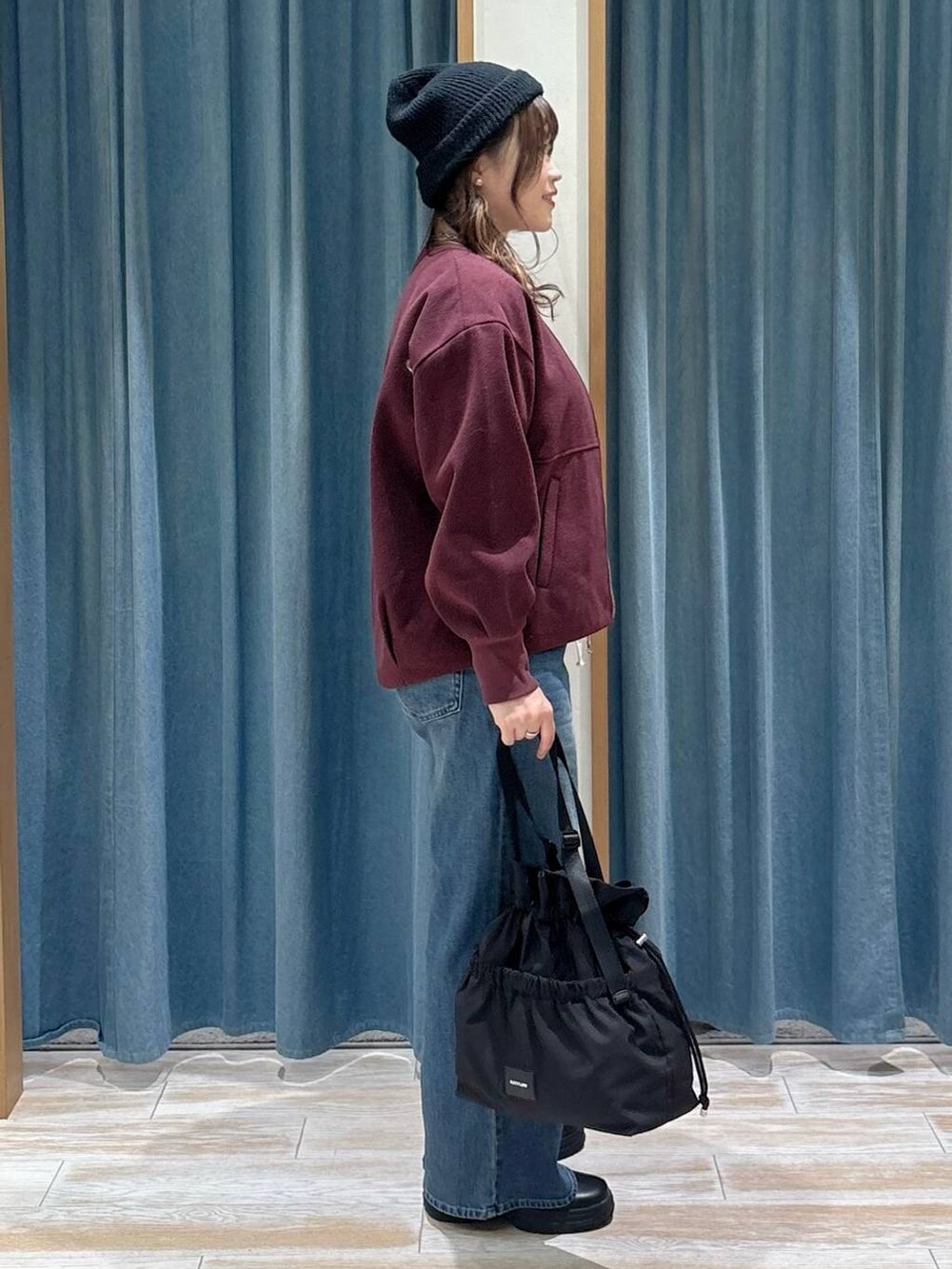 ブラック系のトートバッグ、レッド系のブルゾン、グレー系のベストを着用したレディースの秋コーディネートの2枚目の写真