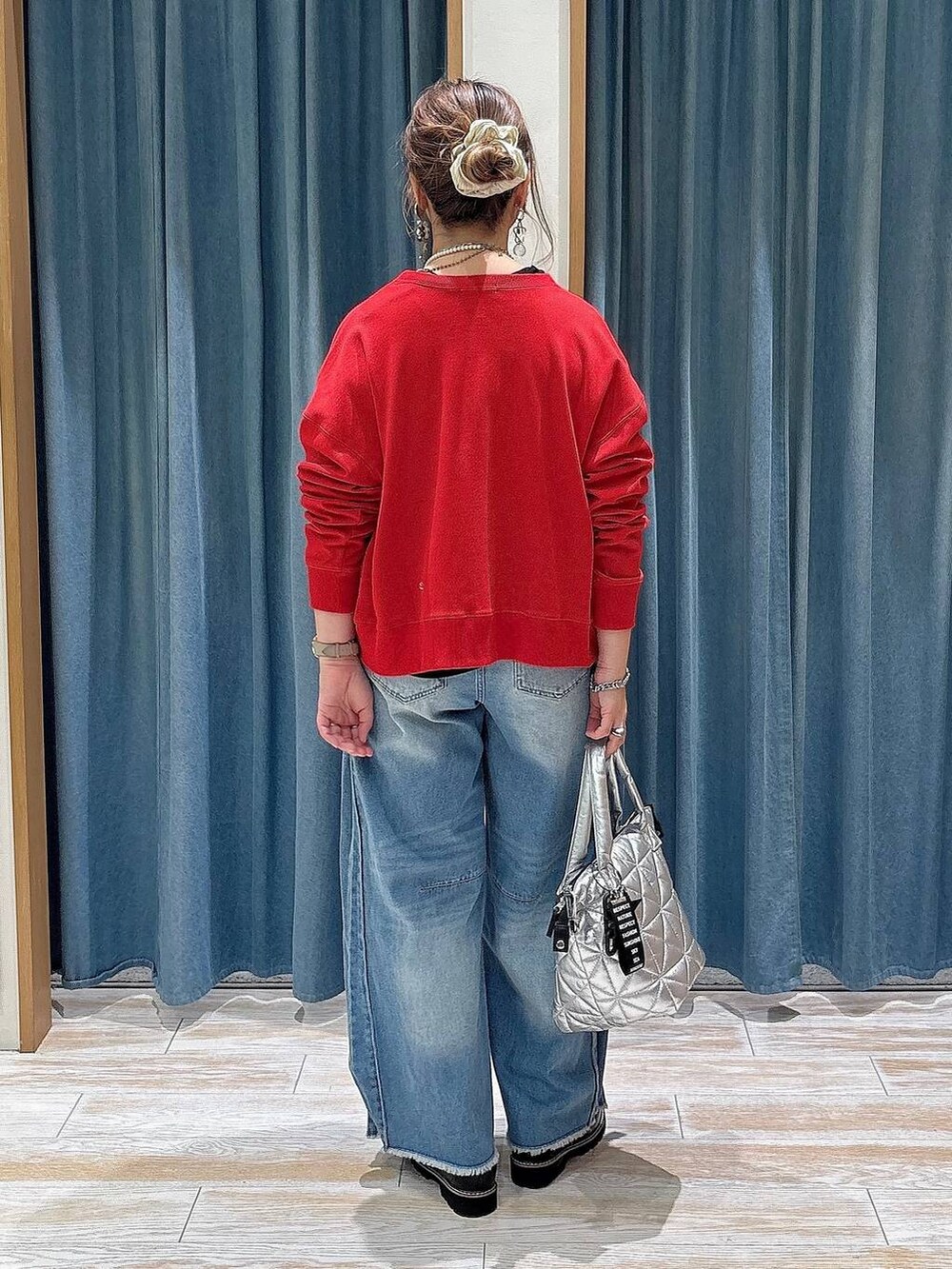 ブルー系のデニムパンツ、レッド系のカーディガン/ボレロ、ブラック系のローファーを着用したレディースの秋コーディネートの3枚目の写真