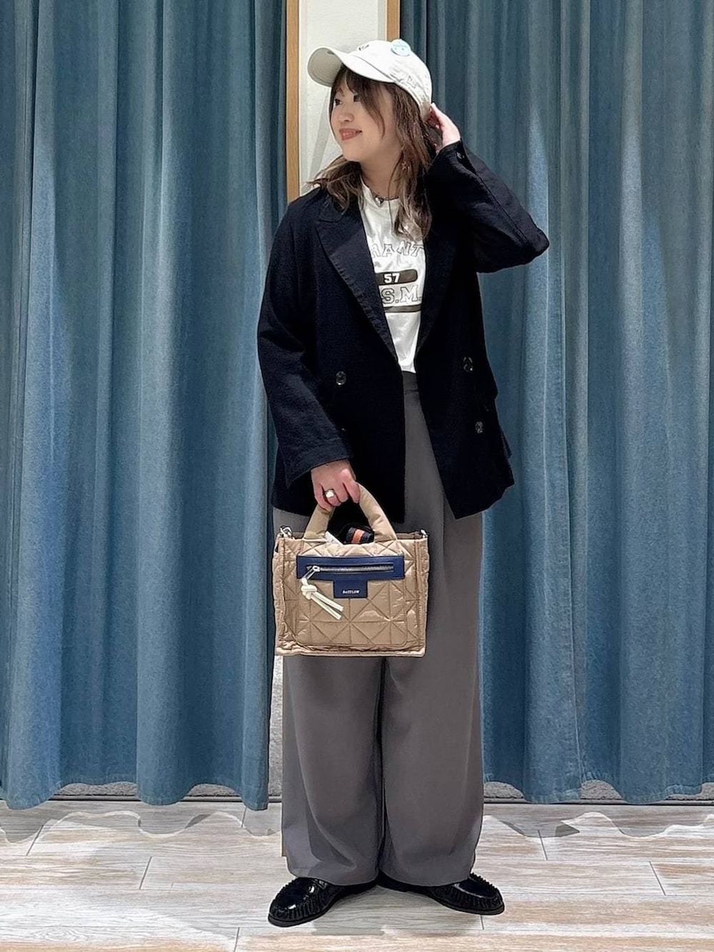 ベージュ系のショルダーバッグ、ホワイト系のTシャツ/カットソー、ブラック系のローファーを着用したレディースの春コーディネートの4枚目の写真