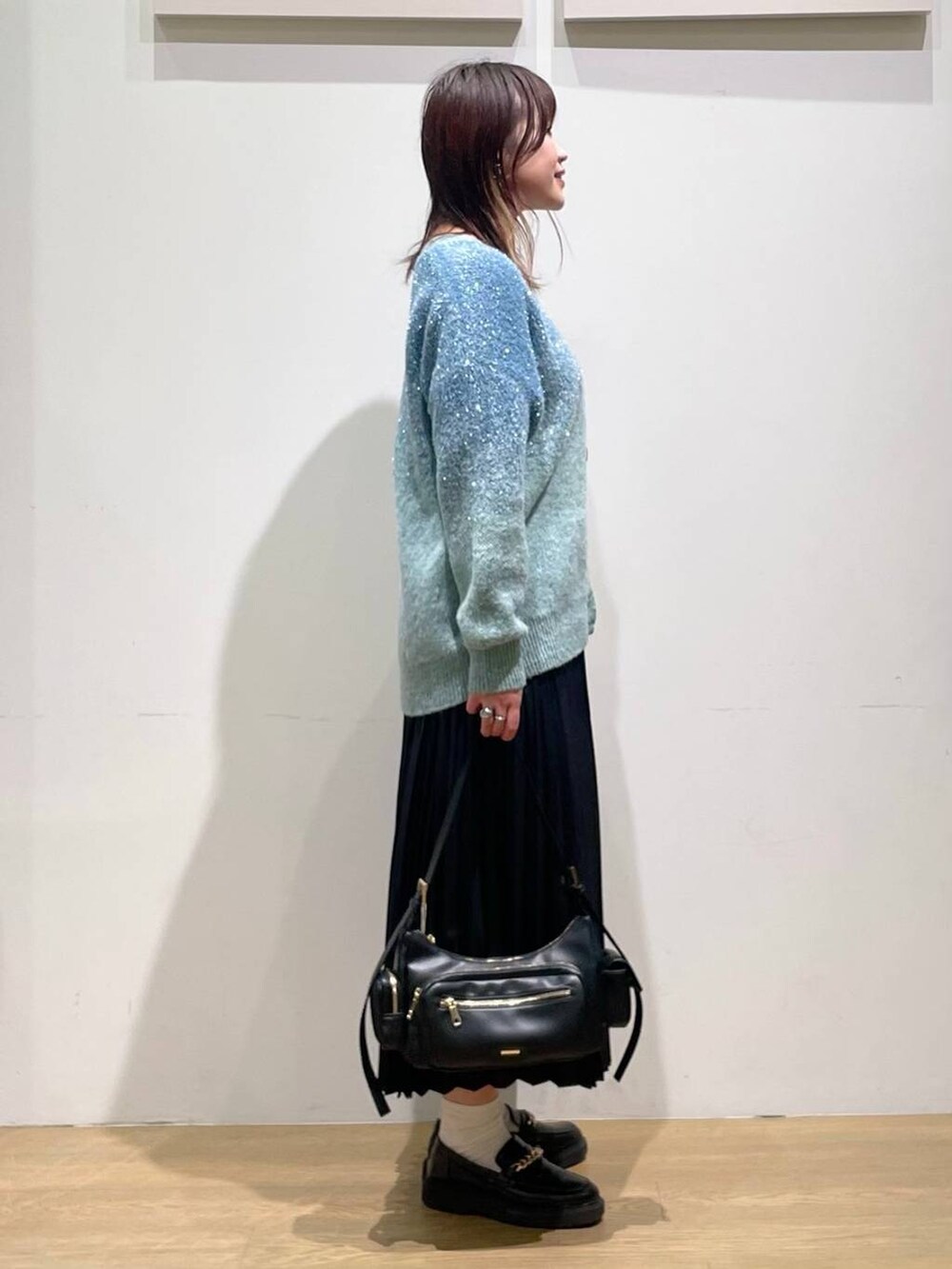 ブラック系のローファー、ブラック系のハンドバッグ、ホワイト系のキャミソールを着用したレディースの秋コーディネートの2枚目の写真